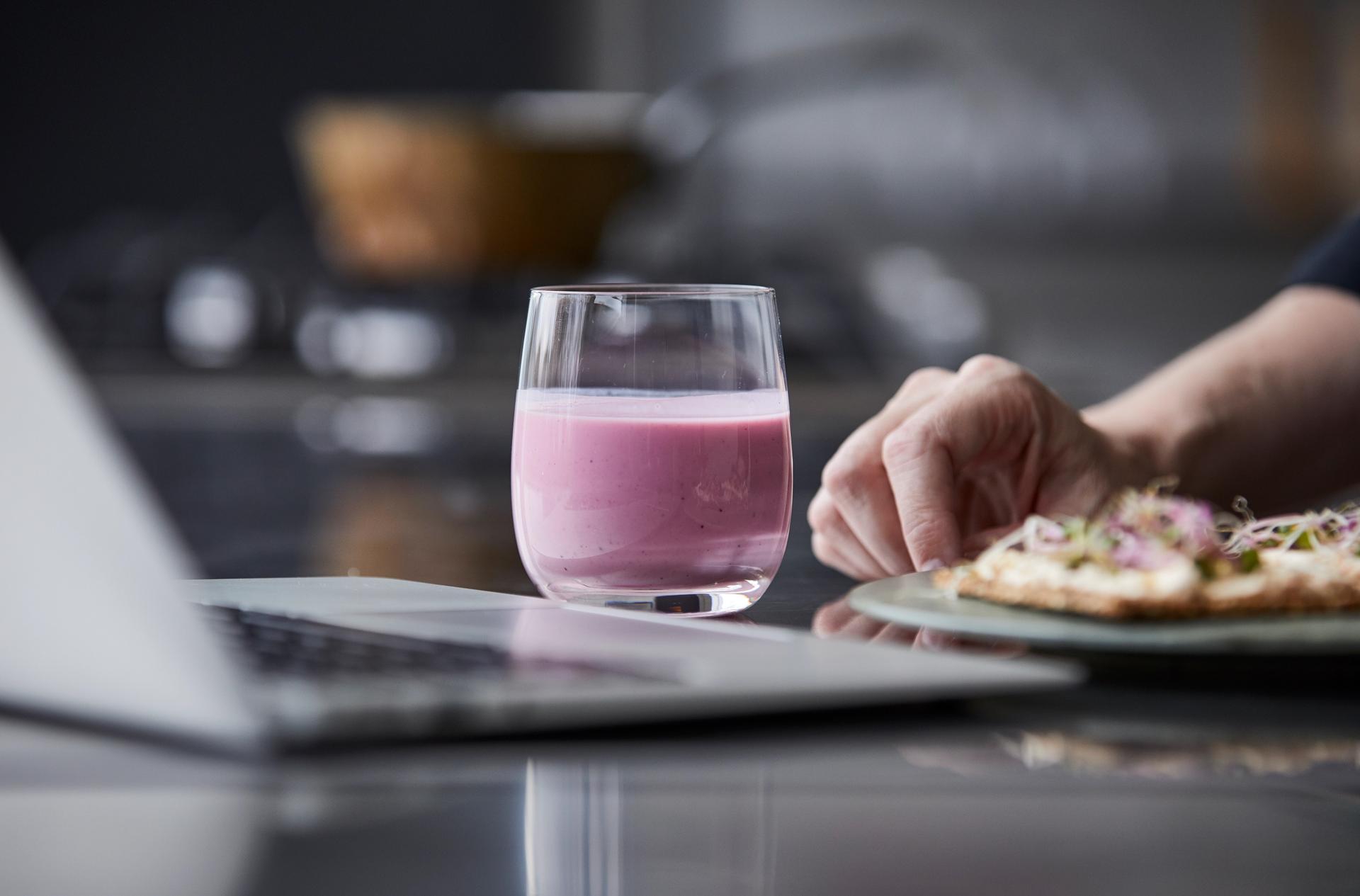 Tallerken med mat foran laptop