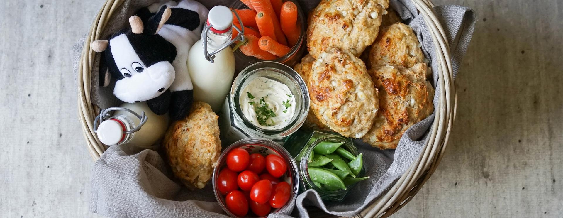 kurv med scones, grønnsaker og melkeflasker