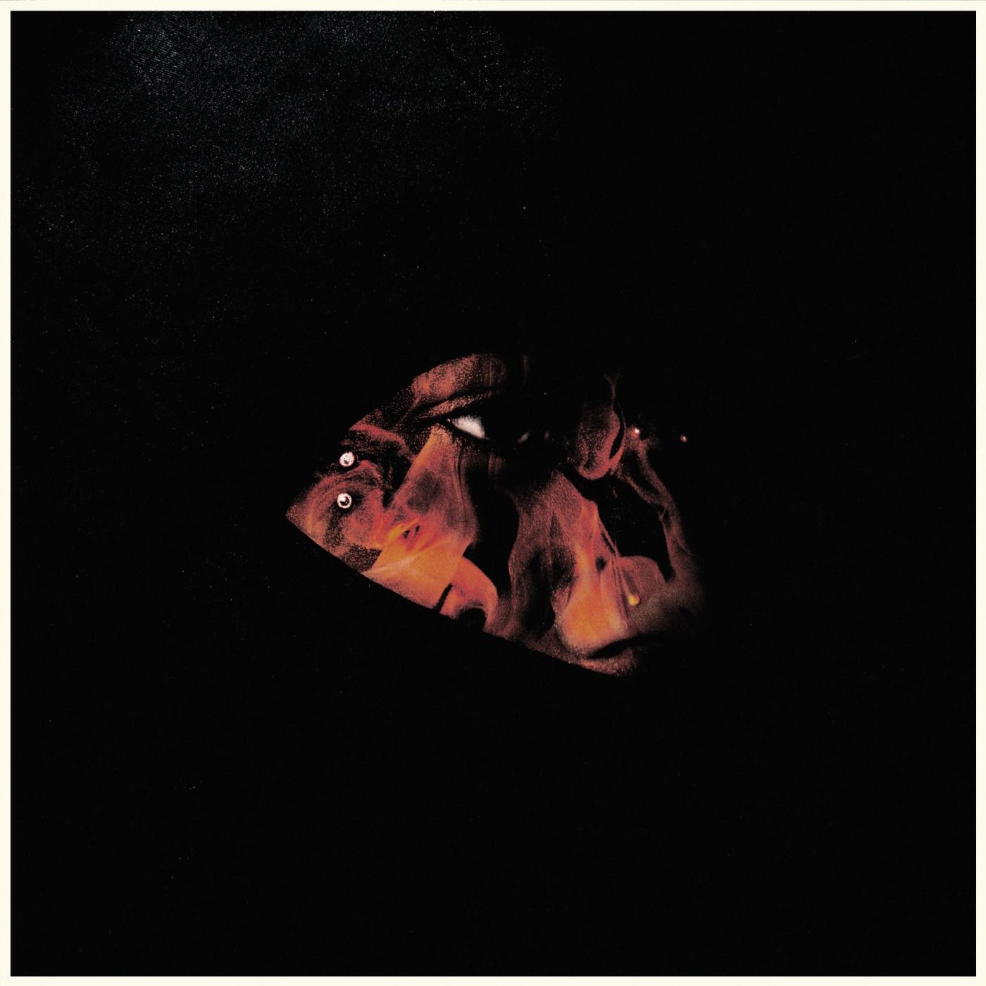 Demon Heart Radio cover: a face lit in red and orange glows inside a small patch of light on an otherwise black background