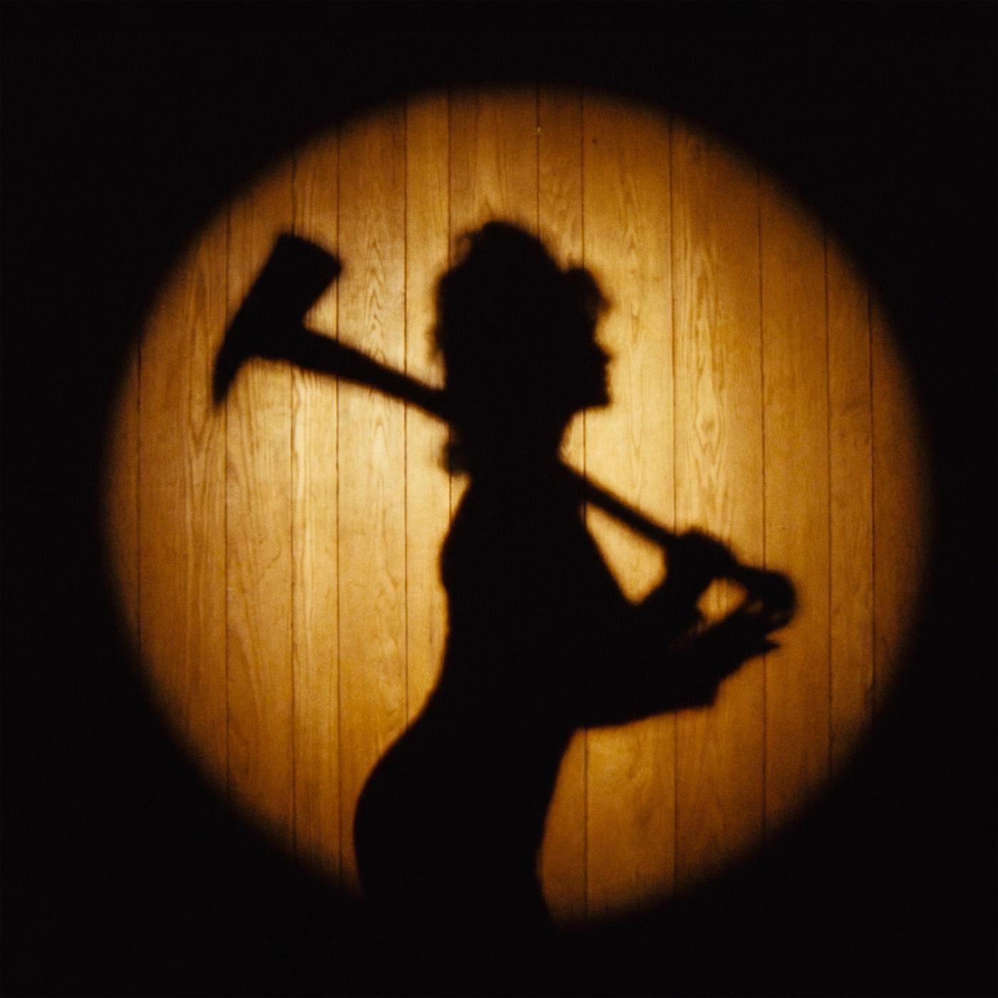 violet single art: the silhouette of a figure holding an axe over one shoulder inside a circle of warm light on a dark wall