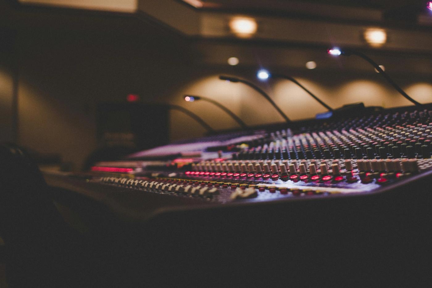 Mixing console with gooseneck lamps in a dimly lit recording studio
