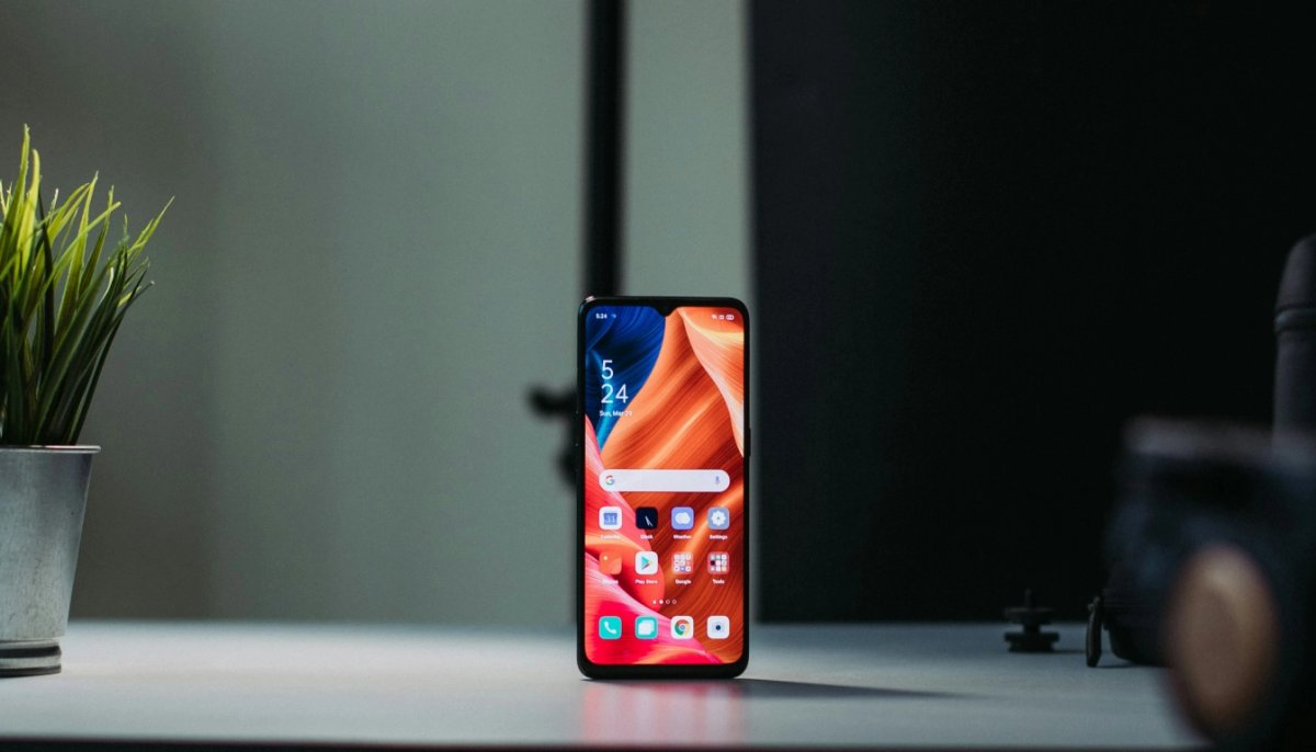 Smartphone on the table near green plant 