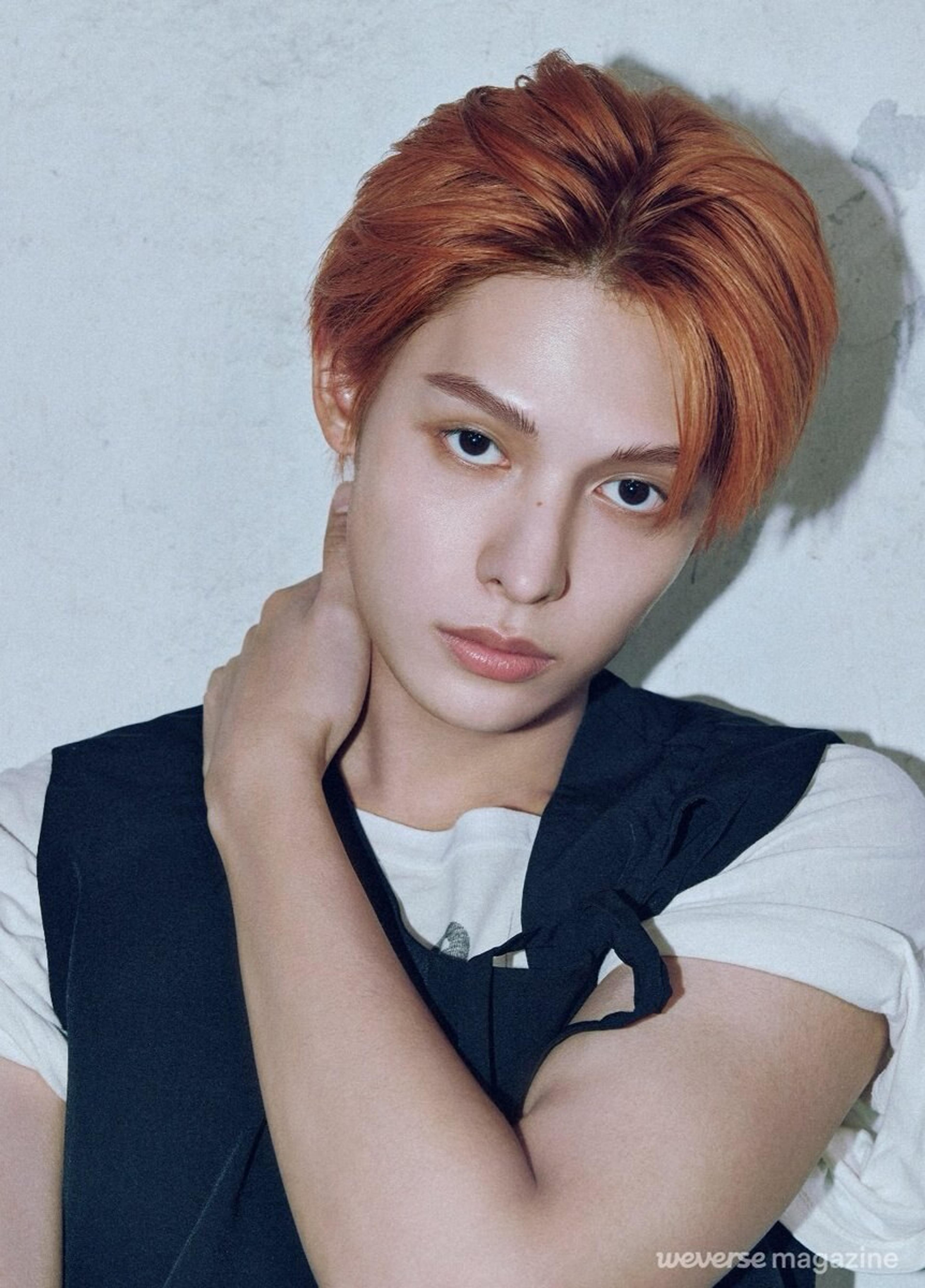 James of CORTIS in an official Weverse Magazine portrait with orange hair and a black vest
