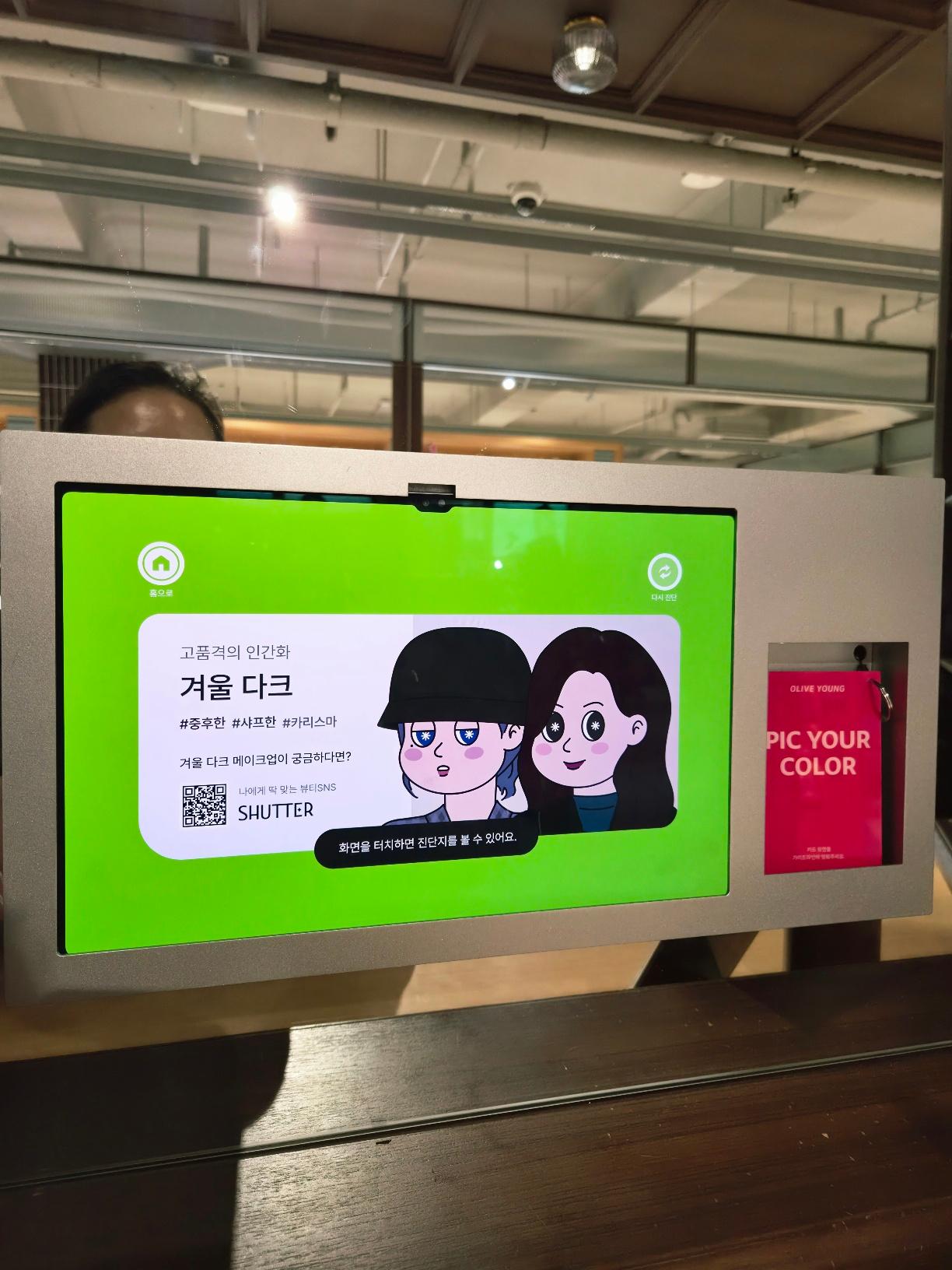 The kiosk screen displaying a Winter Dark result with two illustrated avatars showing recommended styling.