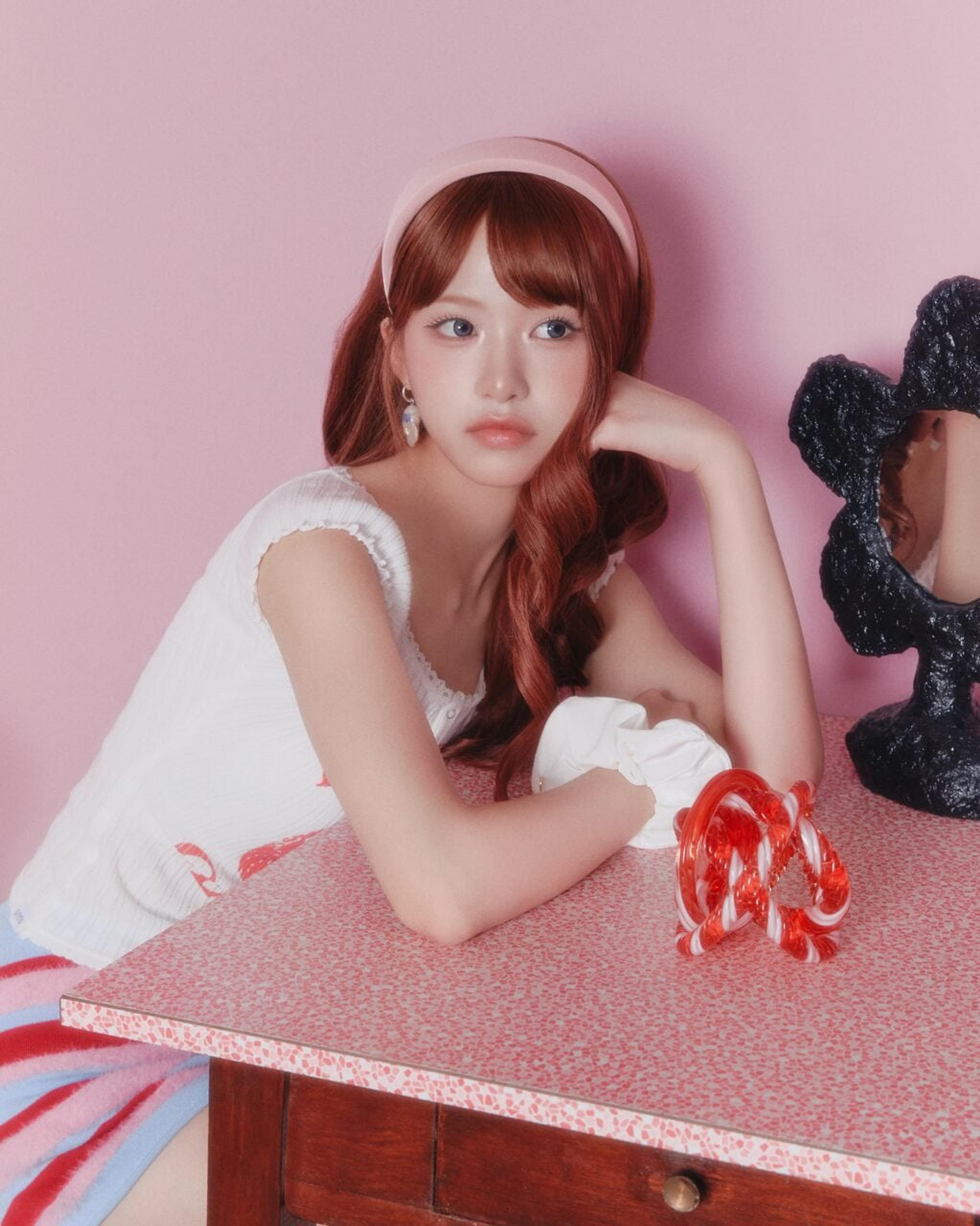 Zena of RESCENE seated at a pink vanity in an official promotional portrait