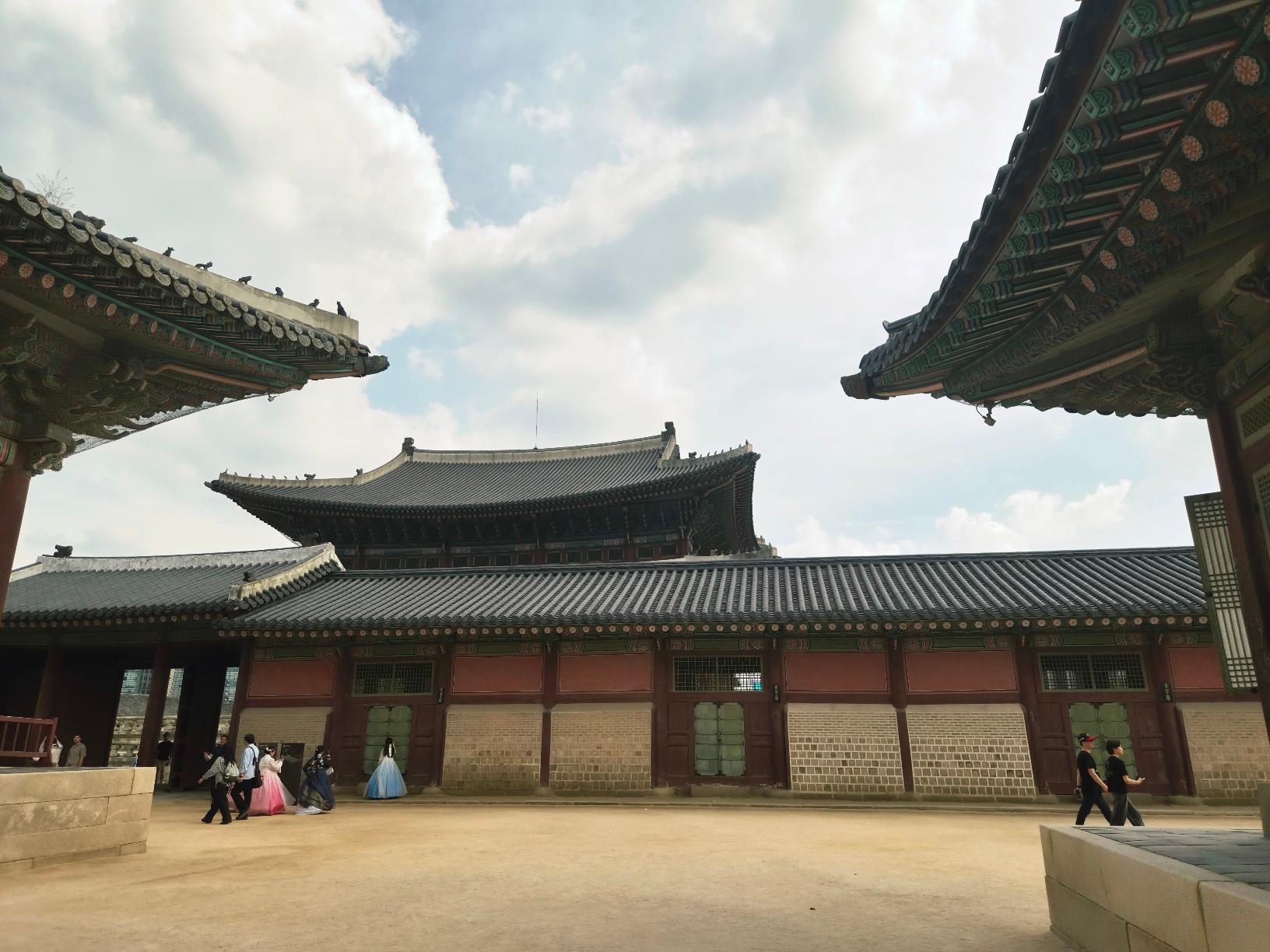 the group of tourists in hanbok posing in the main courtyard