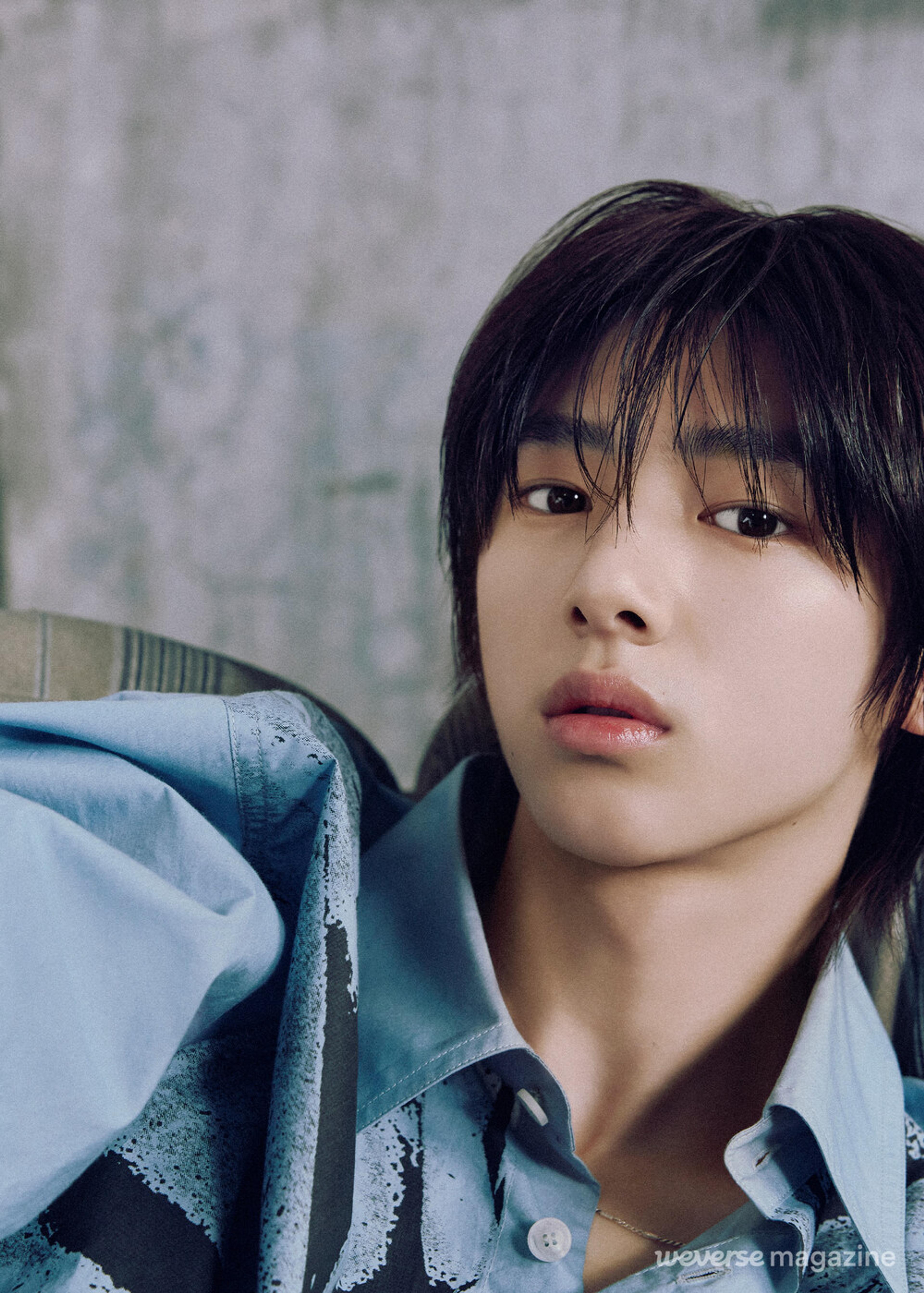 Juhoon of CORTIS reclining in a blue patterned shirt in an official Weverse Magazine portrait