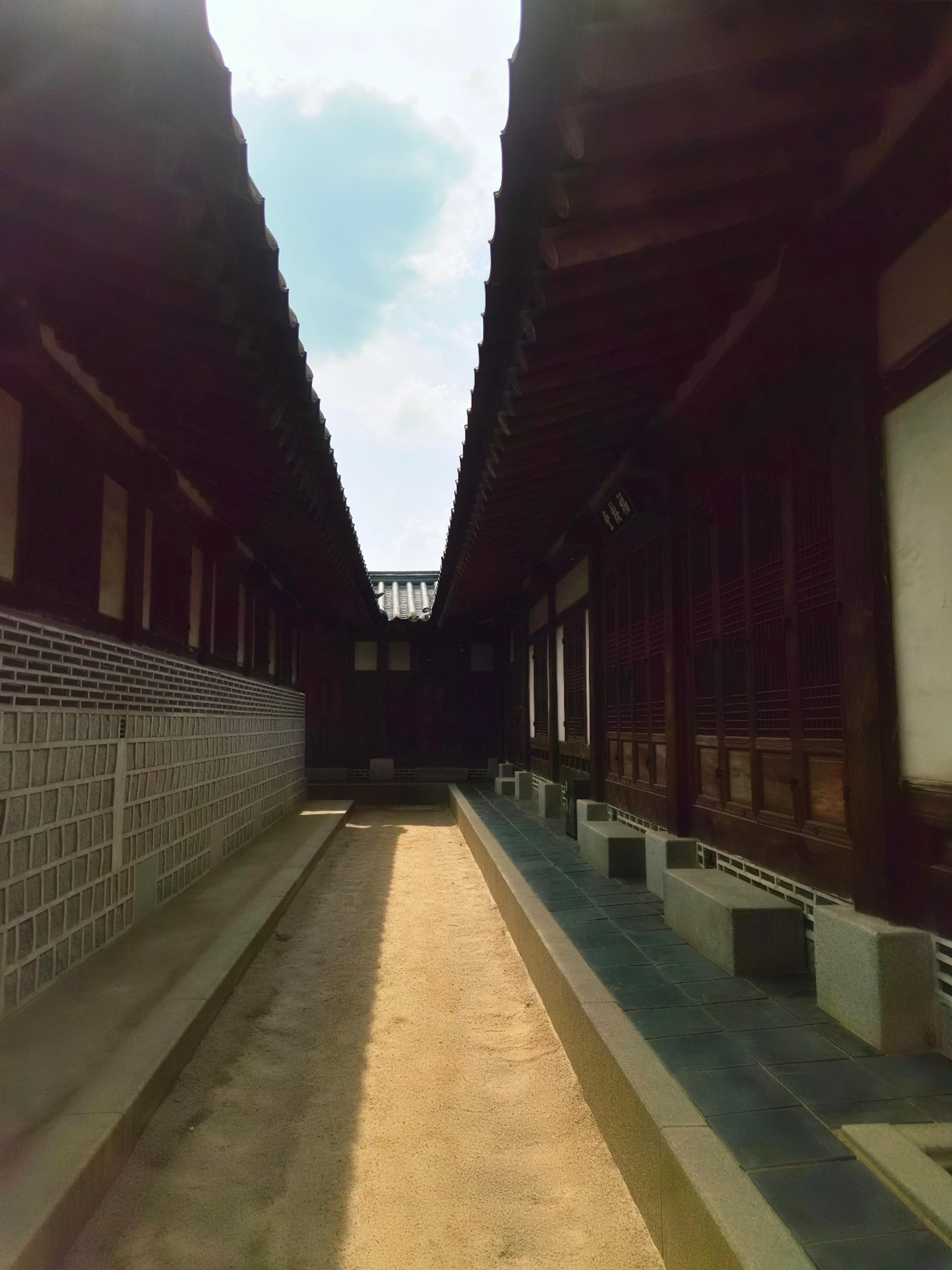 the long corridor with the colorful dancheong painted eaves stretching into the distance