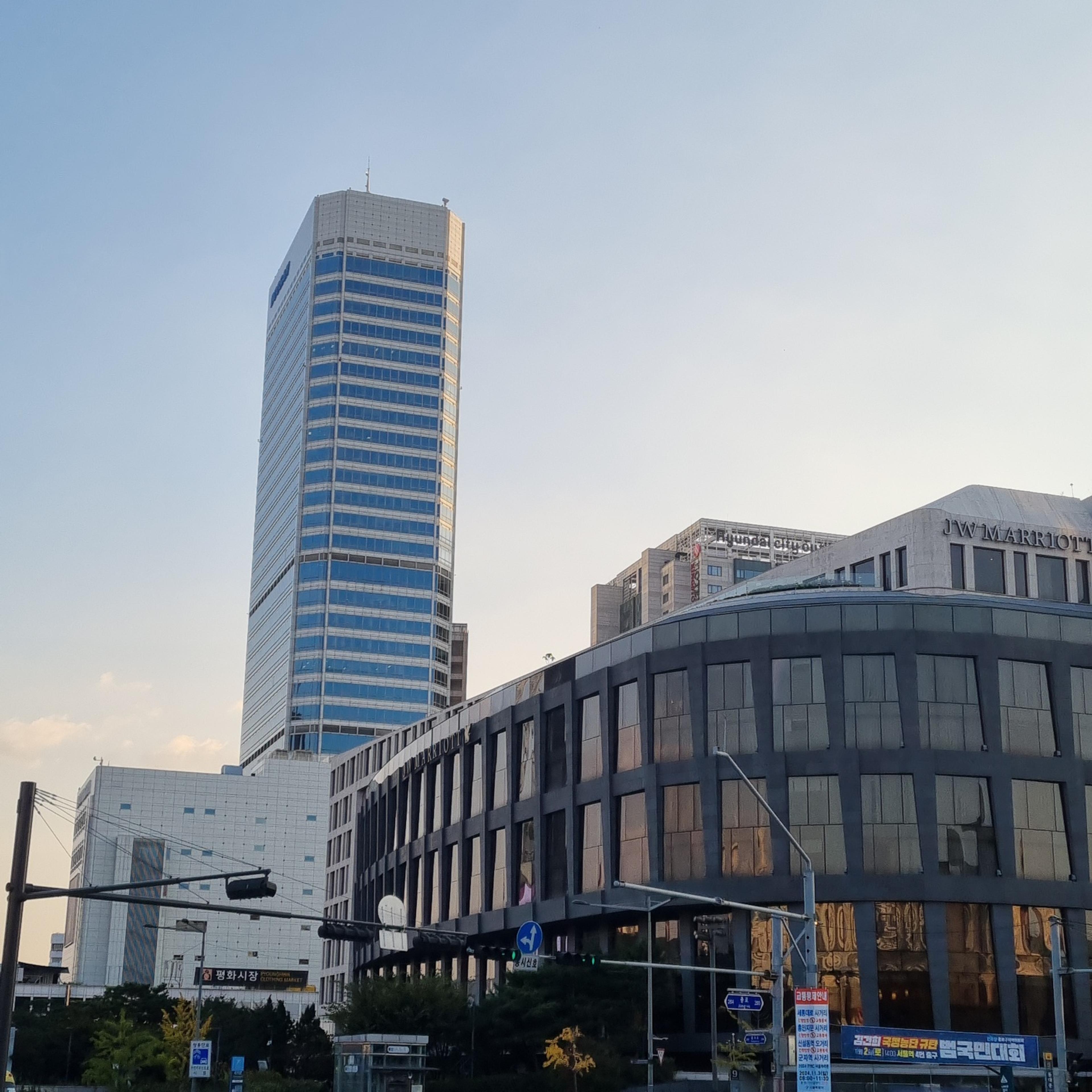 Modern city buildings blending perfectly with the traditional roof of Heunginjimun Gate in Dongdaemun, Seoul.