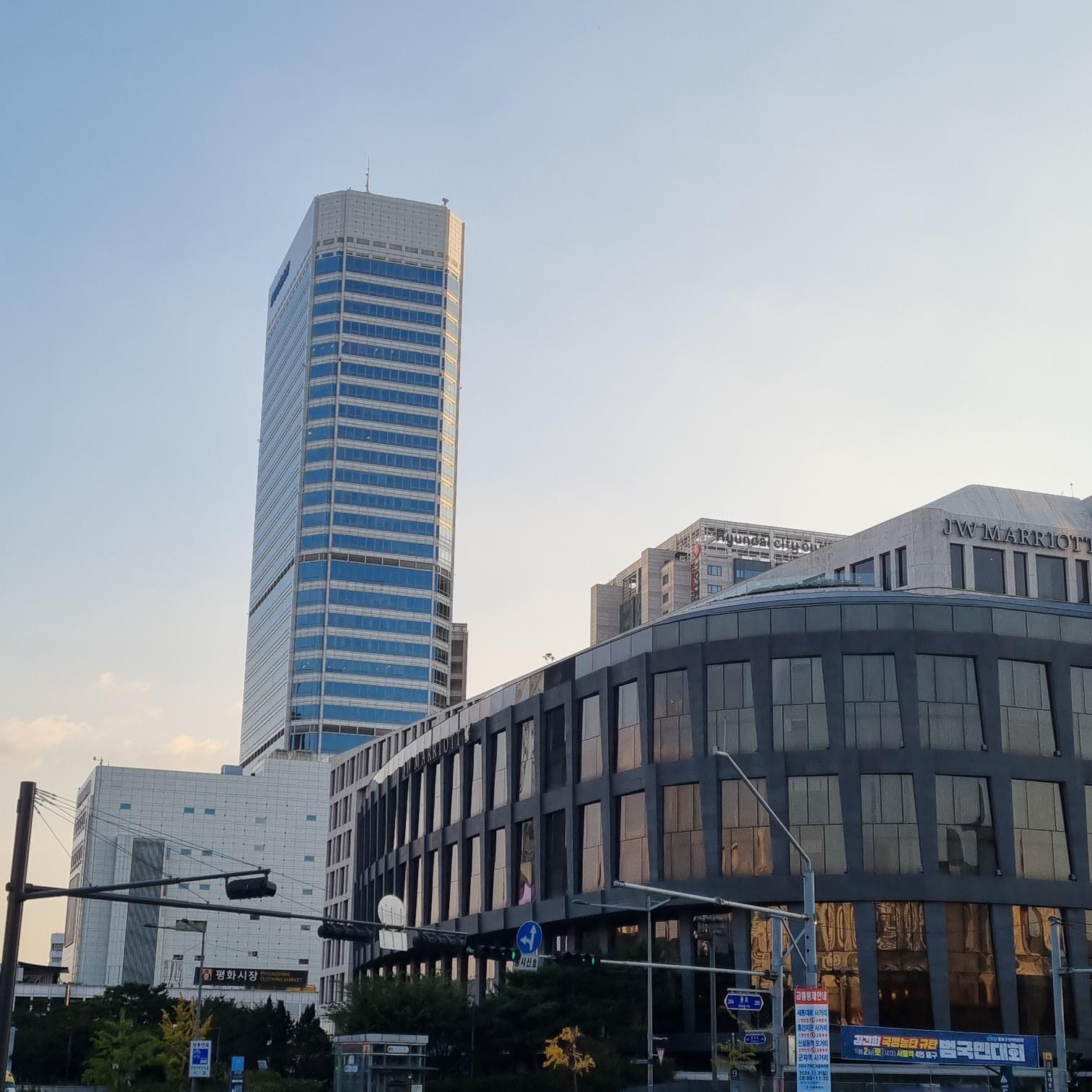 Modern city buildings blending perfectly with the traditional roof of Heunginjimun Gate in Dongdaemun, Seoul.