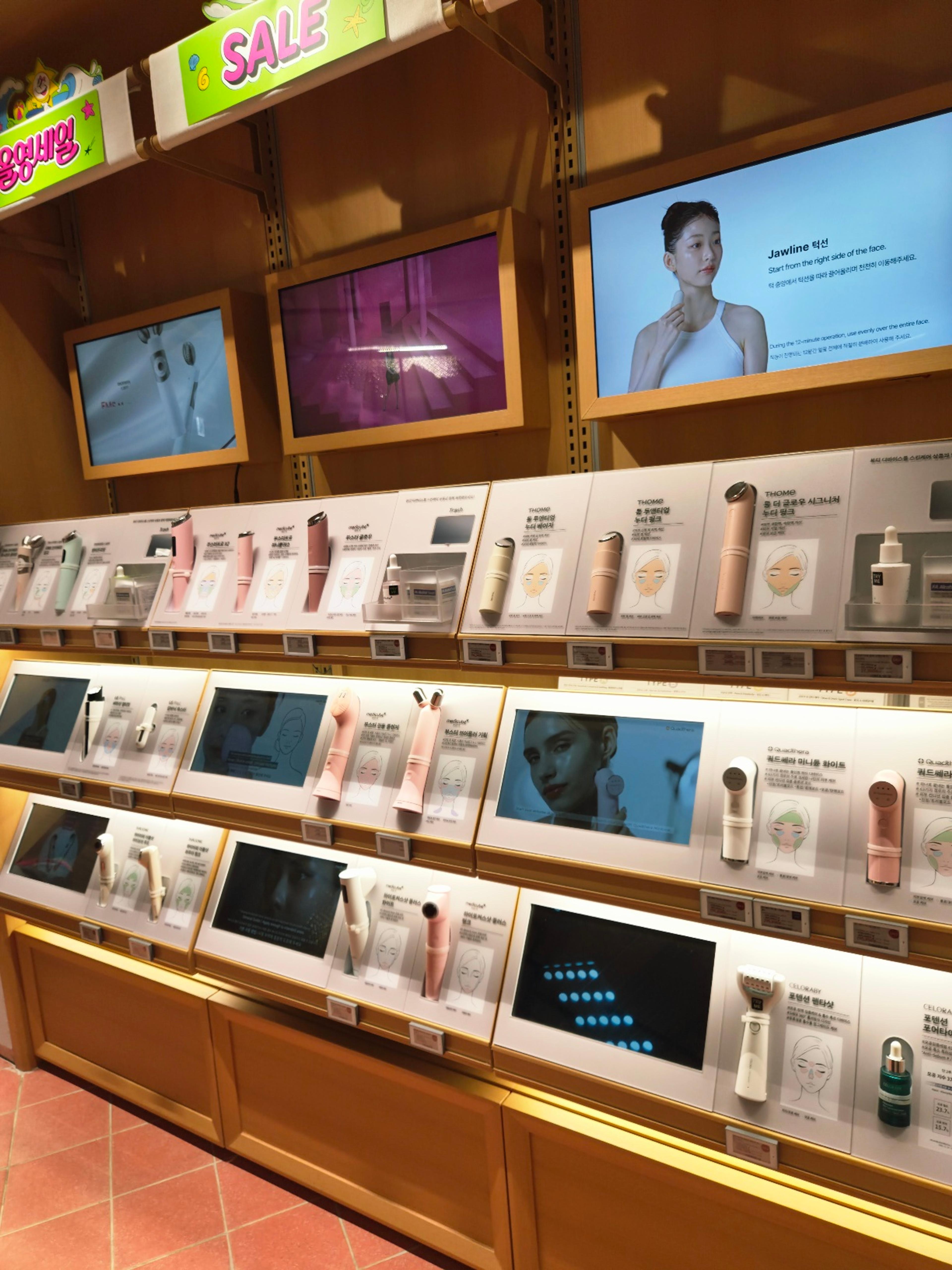 An interactive display wall lined with premium high-tech Korean skincare devices and digital tutorial screens.