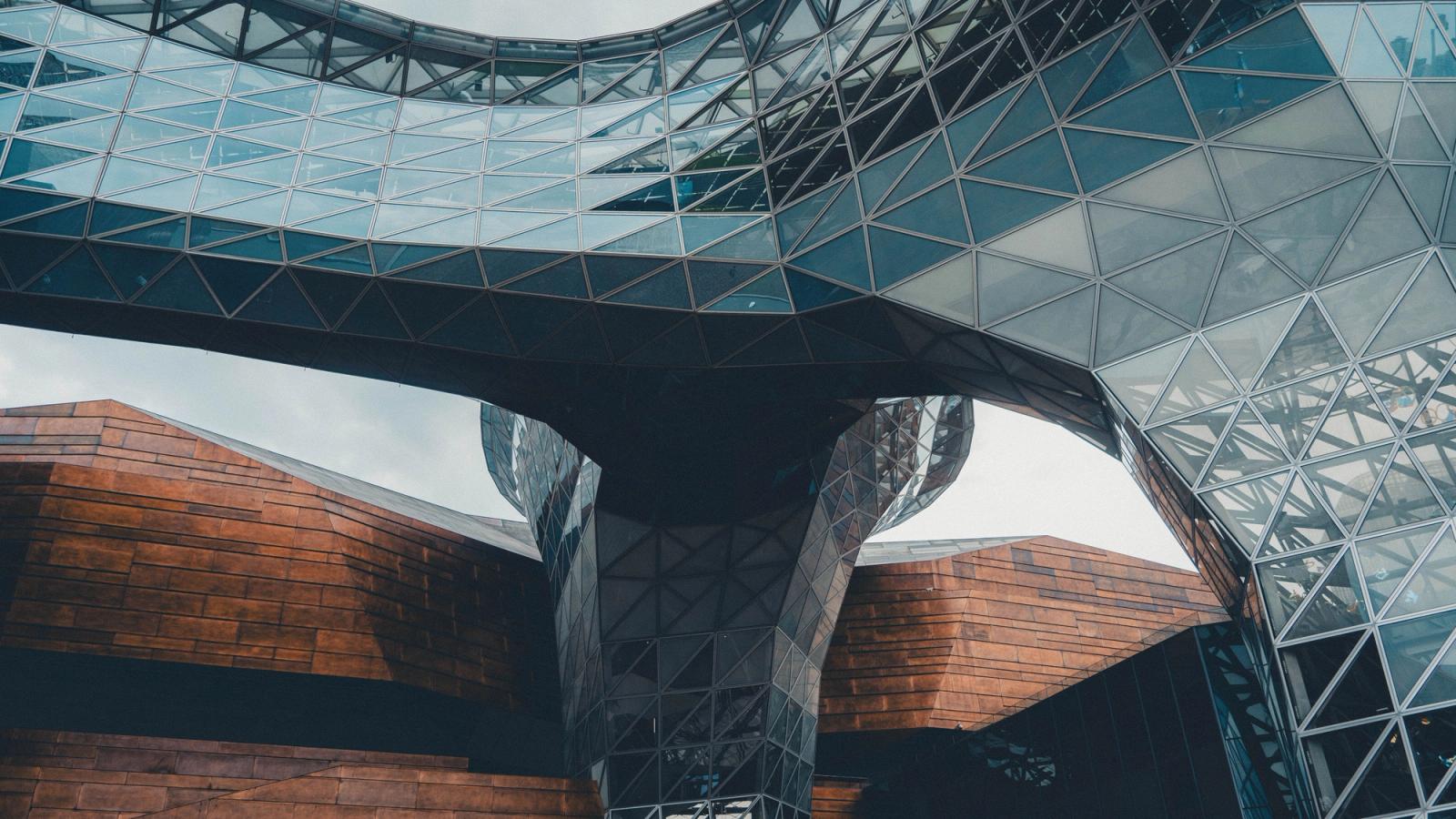 Dynamic view of a modern architectural structure with glass and steel elements.