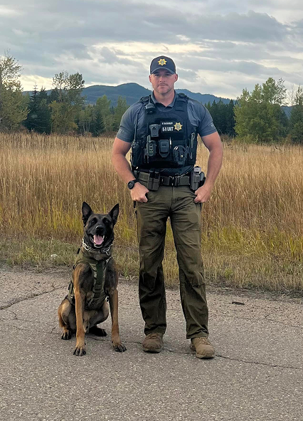 A law enforcement officer with their dog.