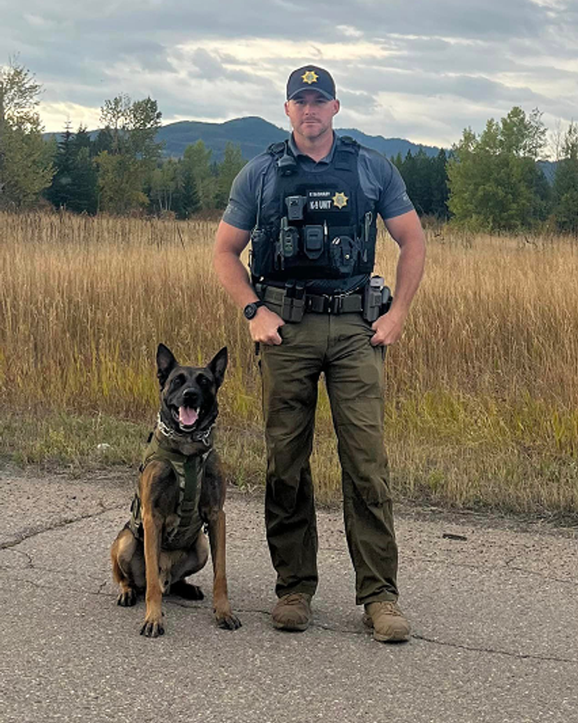 A law enforcement officer with their dog.
