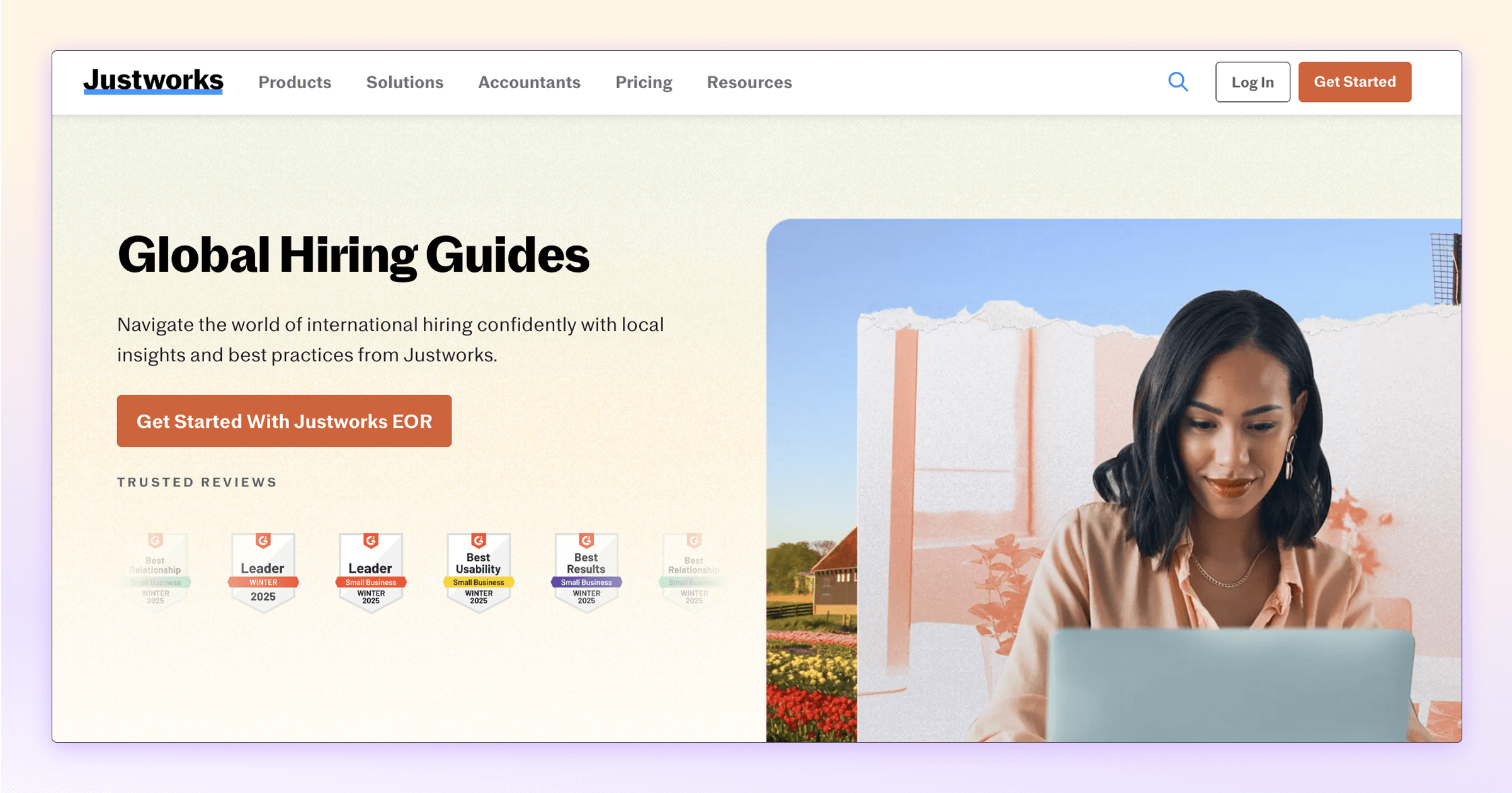 Justworks homepage featuring global hiring guides and a woman working on a laptop.