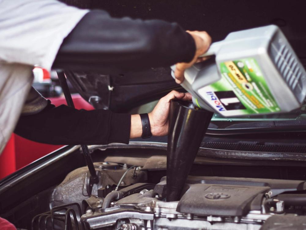 Mechanic topping up engine oil