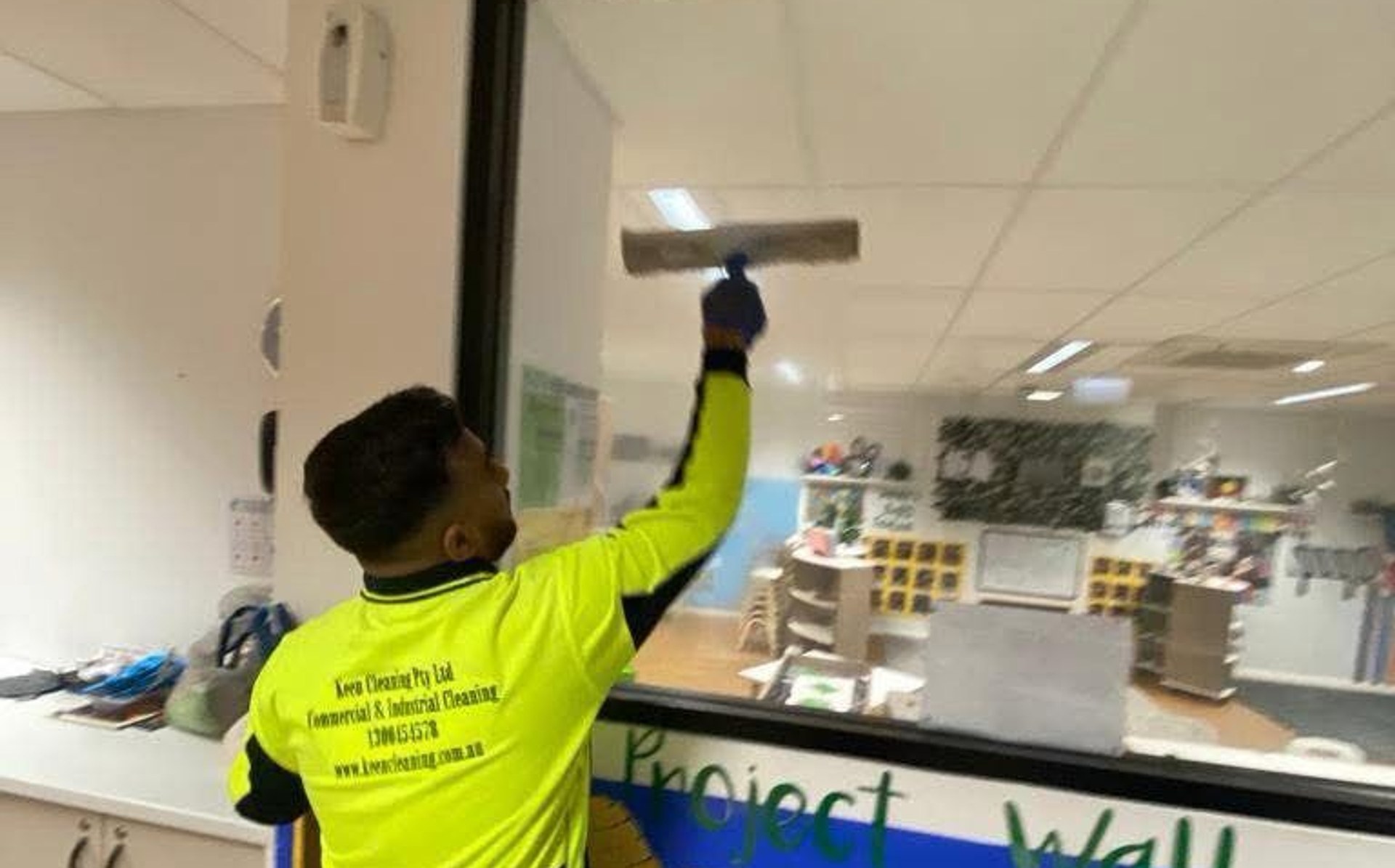 Keen Cleaning technician cleaning interior glass in a childcare classroom