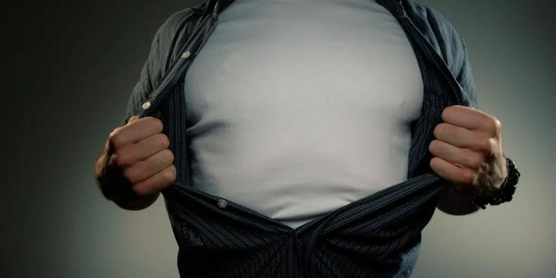 En man visar upp sin stora mage genom att dra skjortan åt sidan