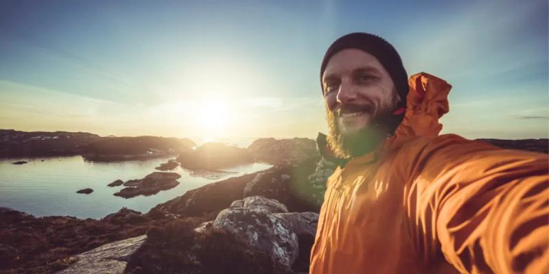 Tilfreds mann som smilende tar en selfie i naturen