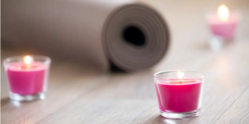yogamatte med rosa tente lys omkring