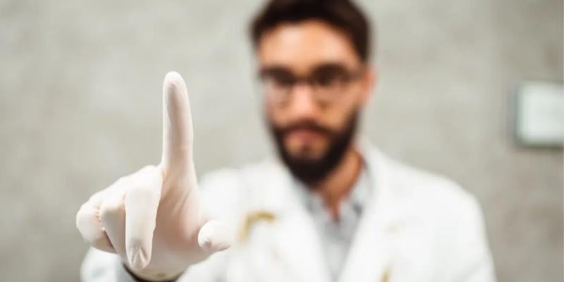 Læge med hvid gummihandske, som holder pegefingeren frem for at foretage en prostata-undersøgelse