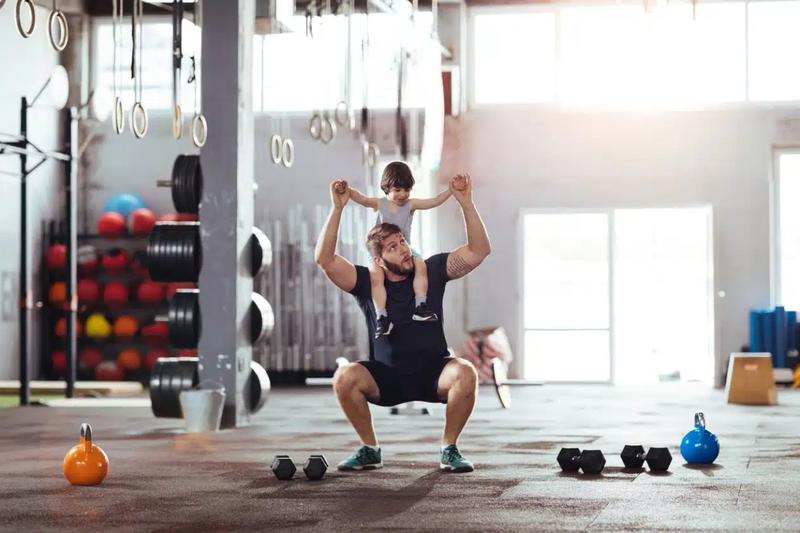 Mann som leker med sin lille sønn i et treningssenter