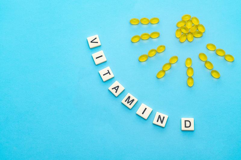 D-vitamin och solstrålar formade av vitaminpiller