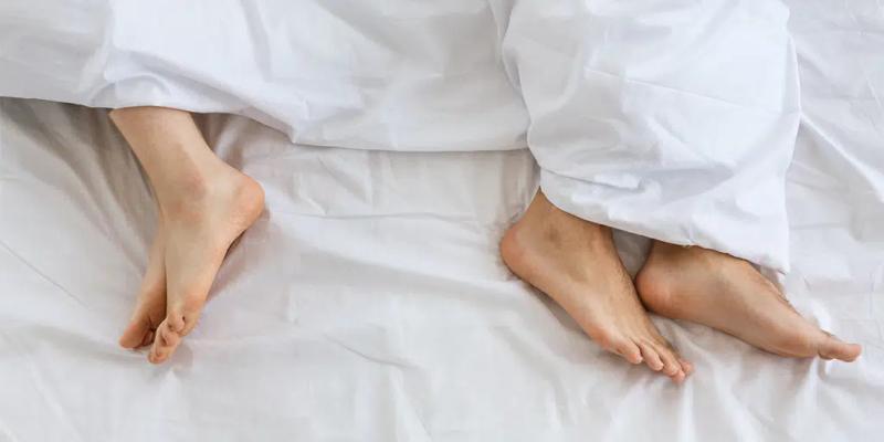 Ett par utan sexlust som ligger i sängen med ryggarna mot varandra