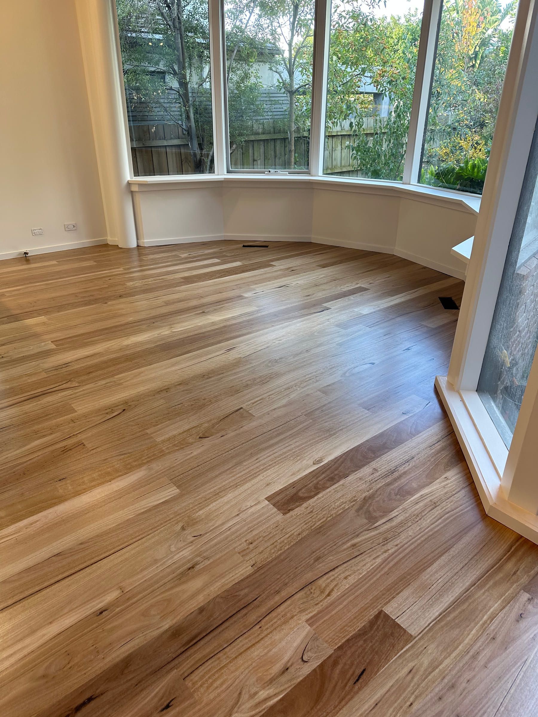 Standard-grade Blackbutt flooring following the curved bay windows of a Malvern room.