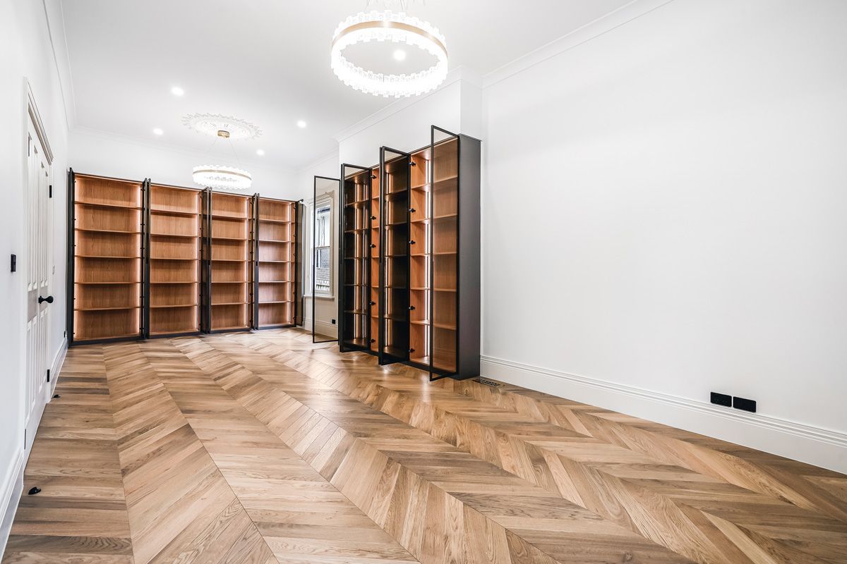 Champagne engineered oak chevron flooring in a Kew library with built-in cabinetry.
