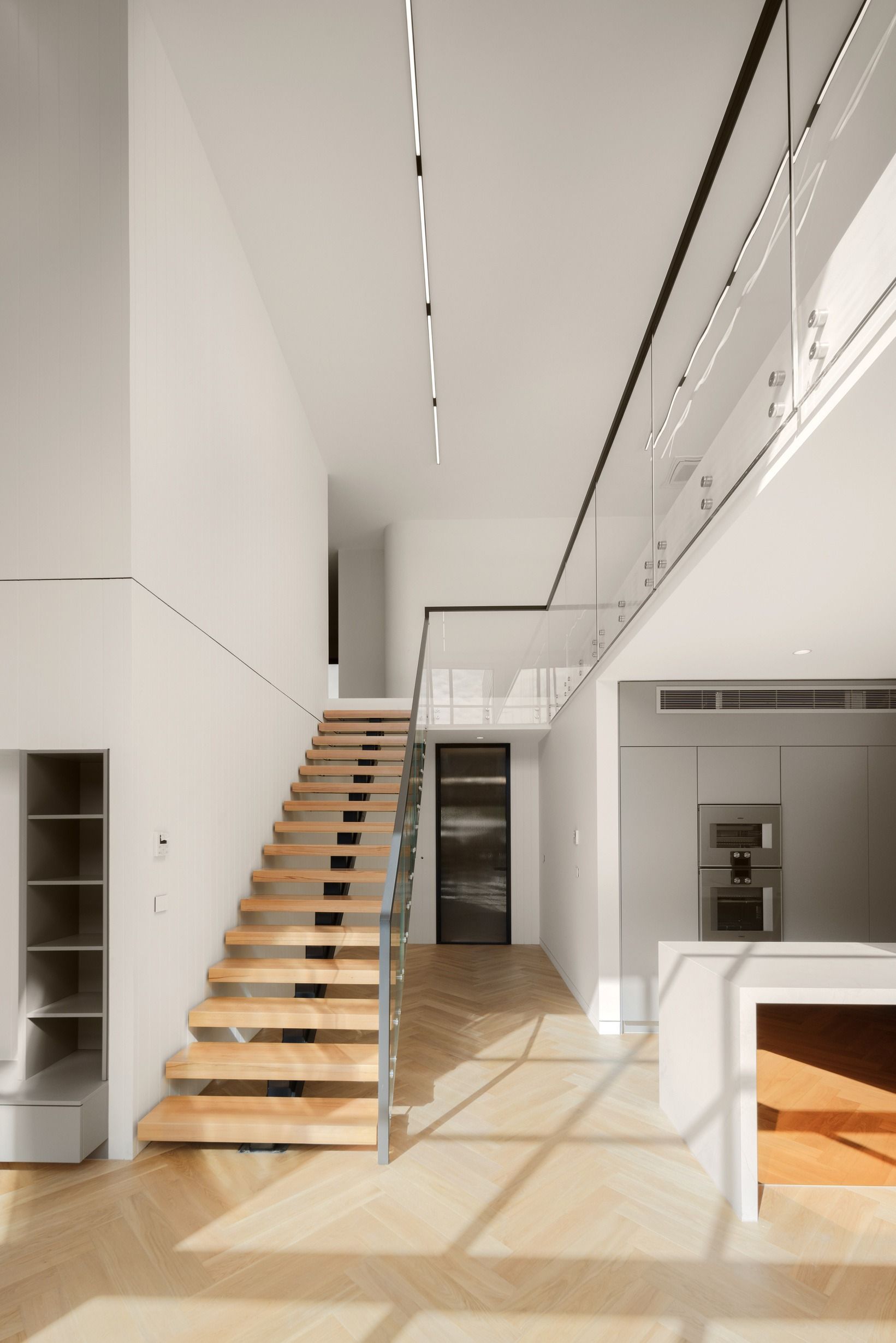 Natural Oak herringbone flooring through a double-height Kew living space.