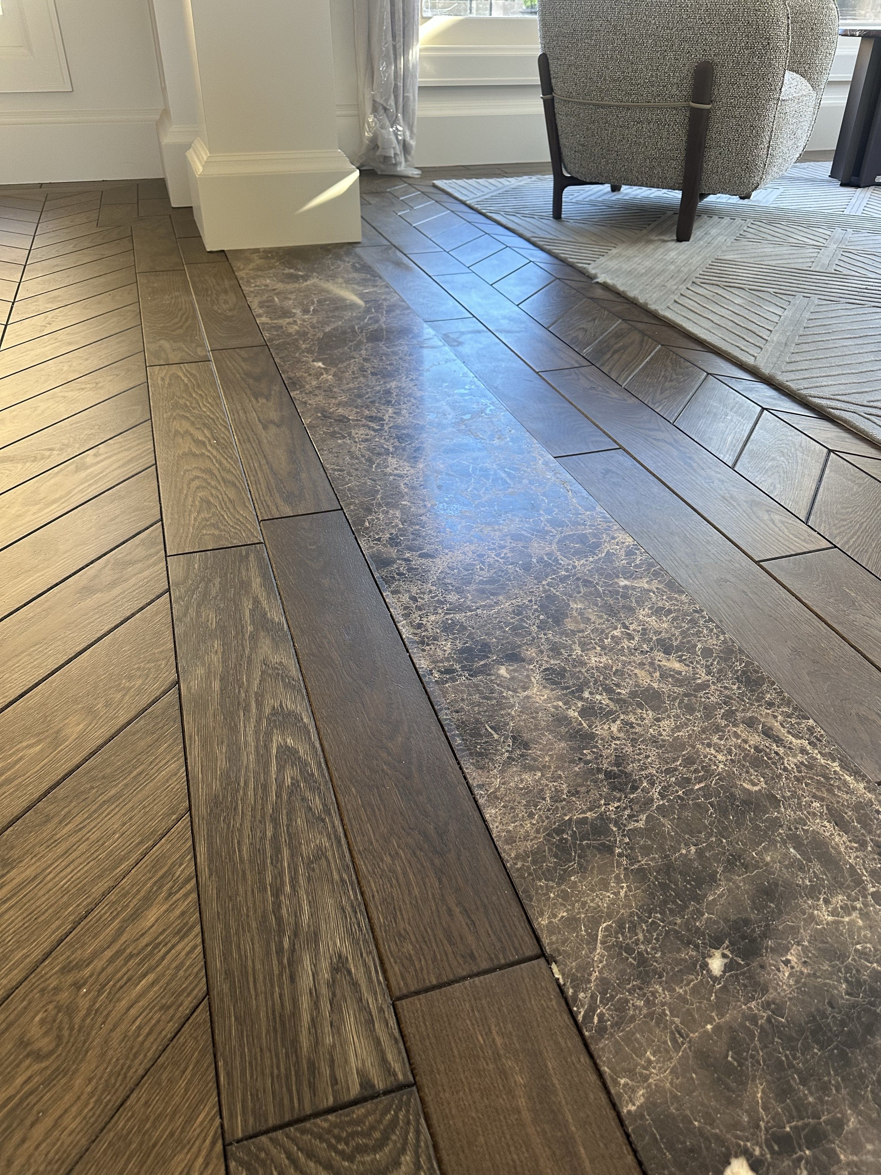 Chevron oak flooring meeting a decorative stone floor inset in Balwyn North.