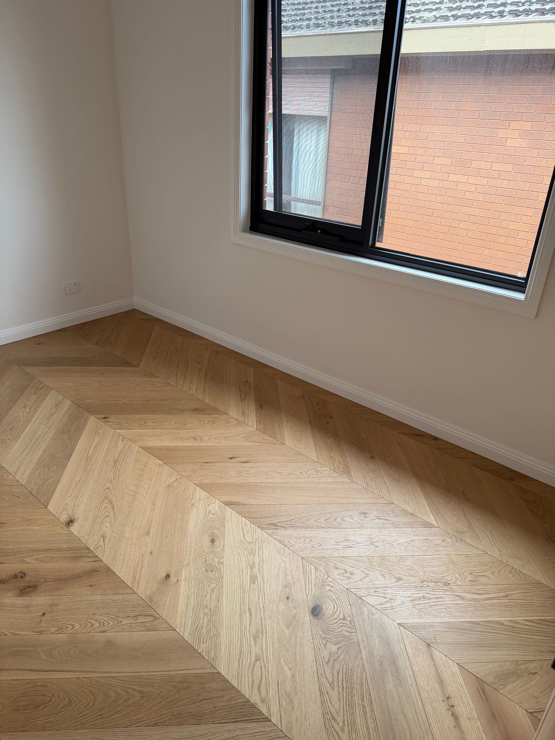 Natural Oak chevron flooring running beneath a bedroom window in the Bulleen residence.