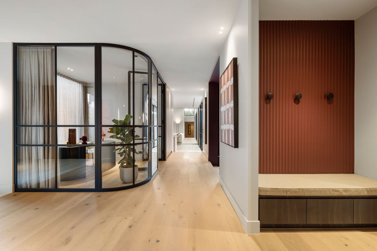 Straight-plank Avoca Bay flooring through a Kew hallway with curved glazing.