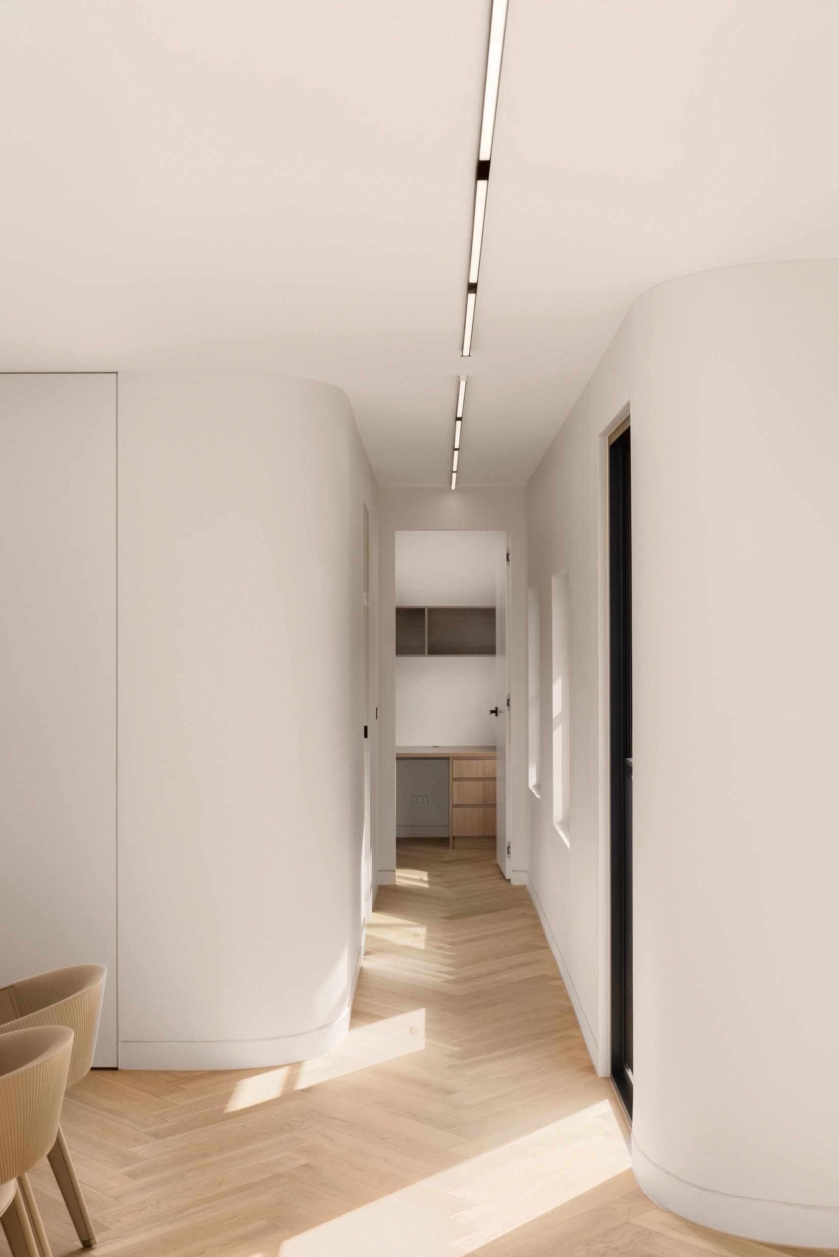 Natural Oak herringbone flooring extending along a curved Kew hallway.
