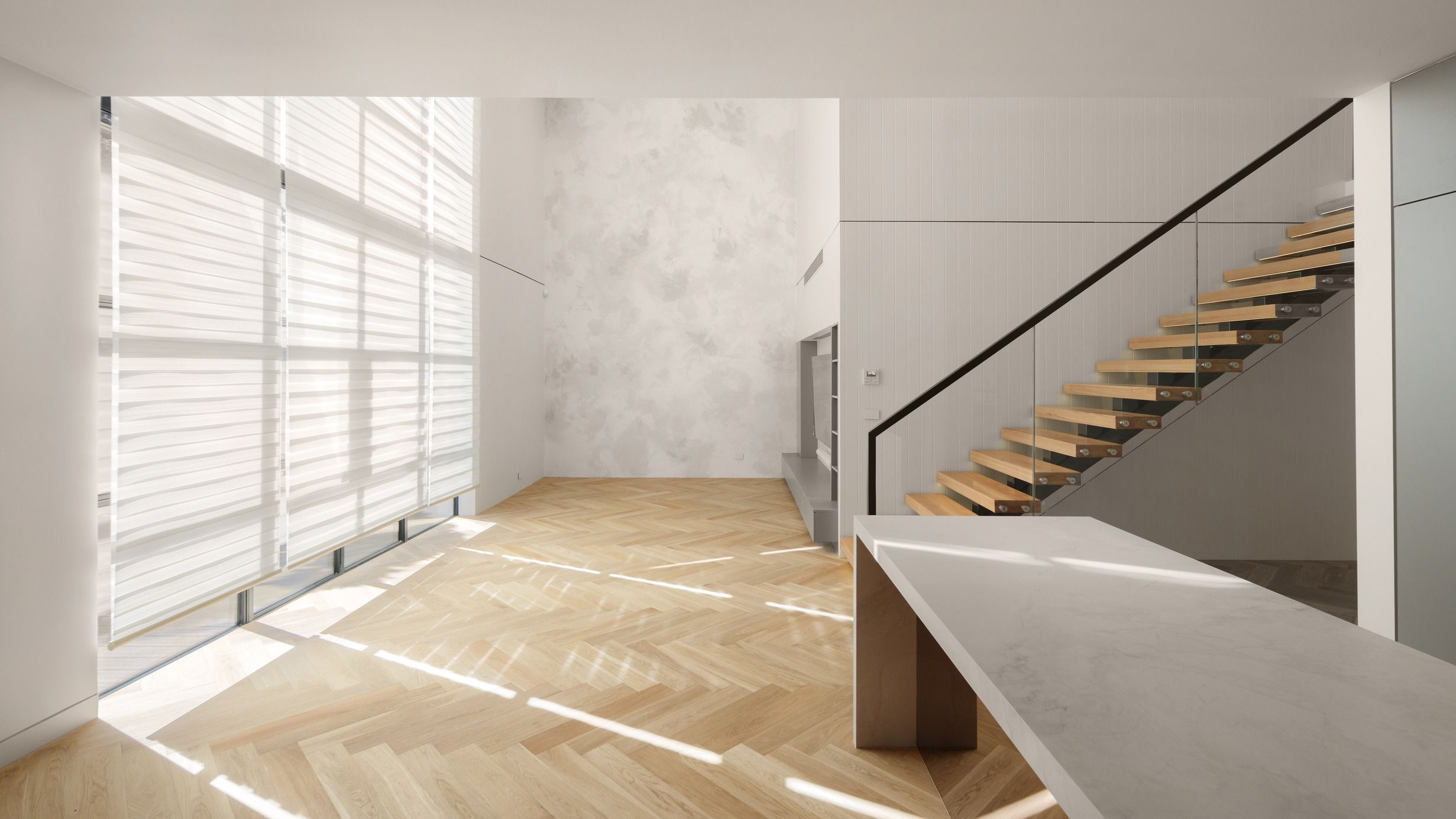 Natural Oak herringbone flooring in a Kew living room with fireplace and staircase.