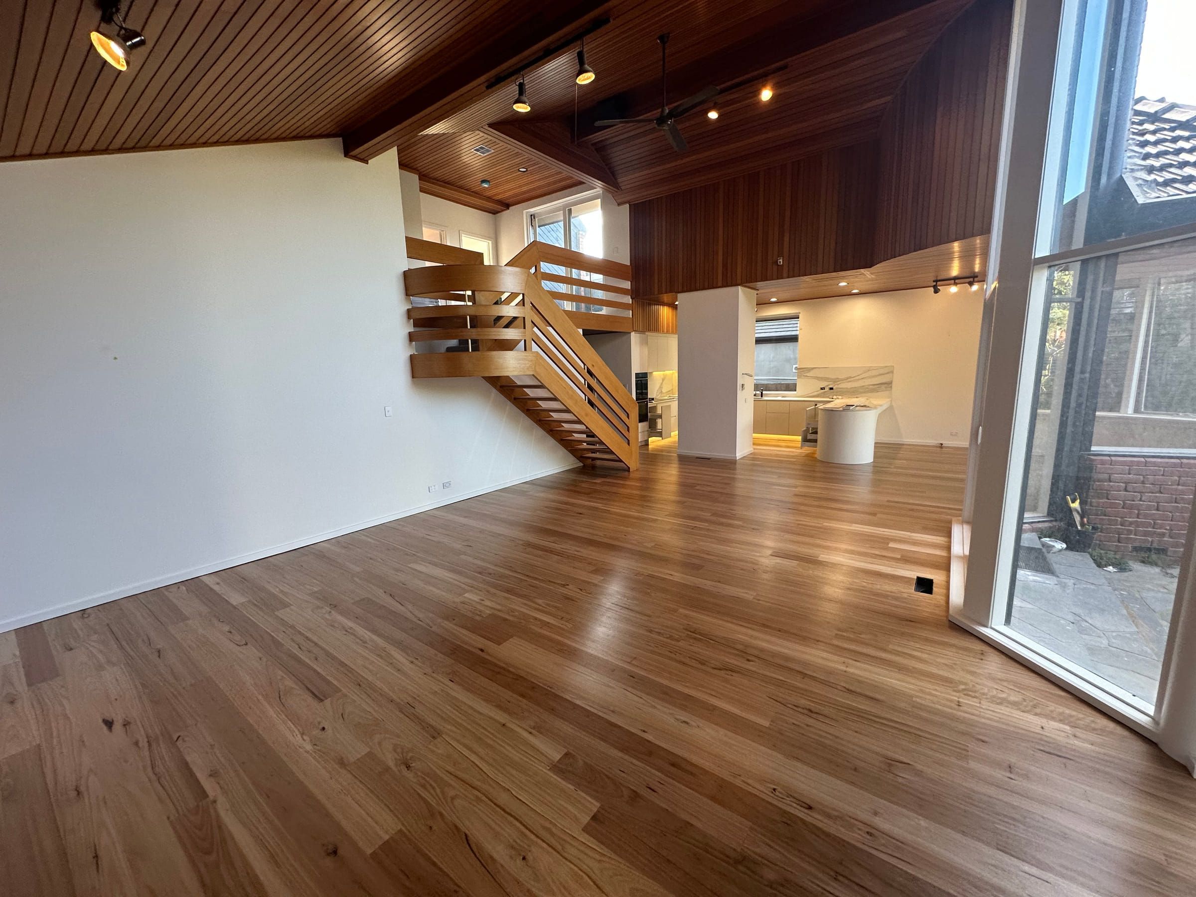 Standard-grade solid Blackbutt flooring in an open-plan Malvern living room with a timber-lined ceiling.