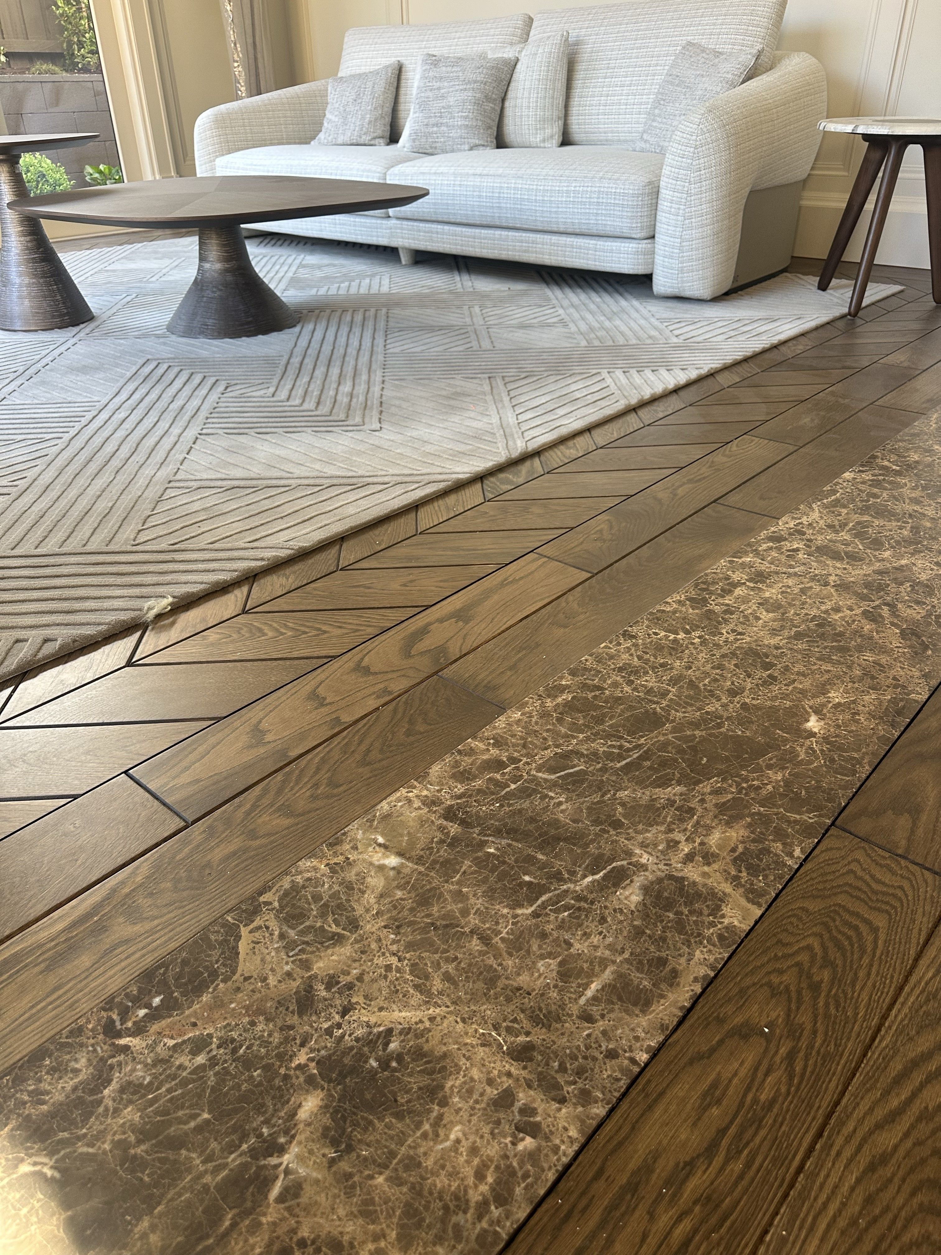 Solid oak chevron flooring fitted beside a stone floor feature.