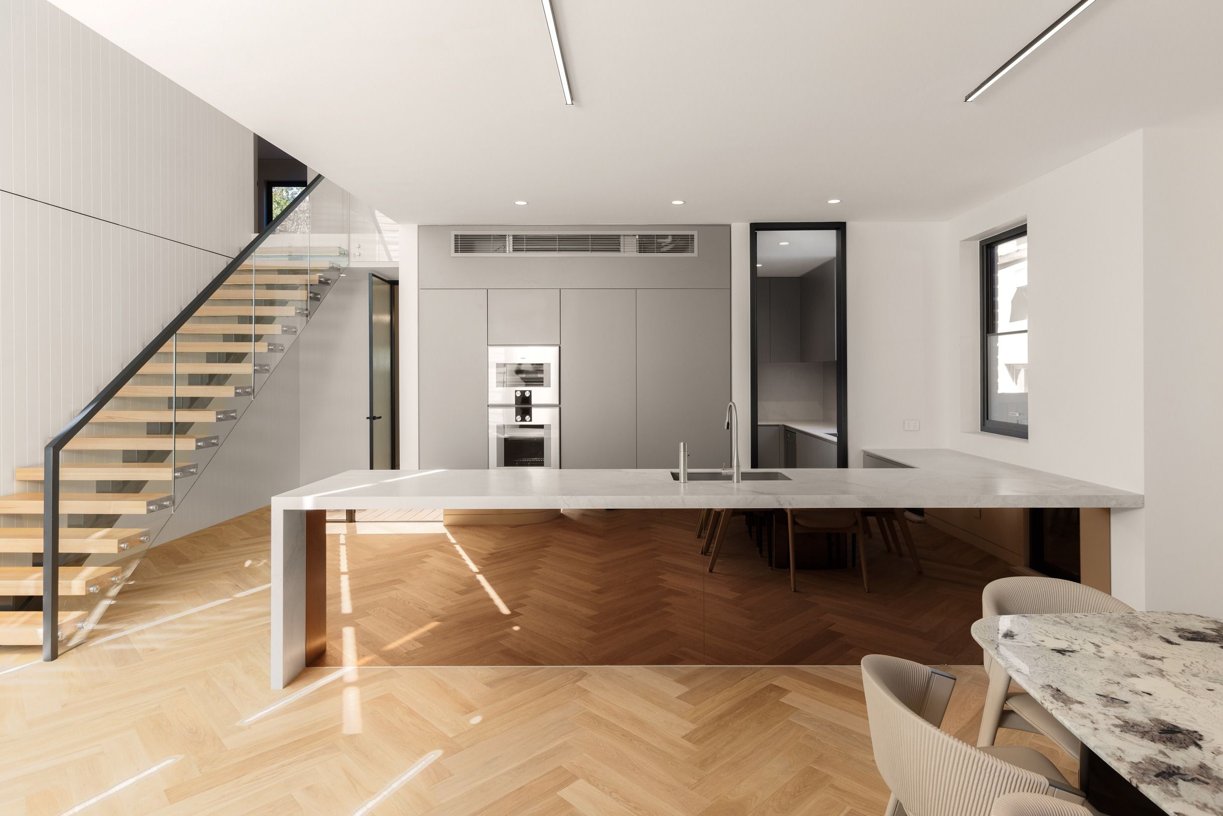 Natural Oak herringbone flooring around a kitchen island in Kew.