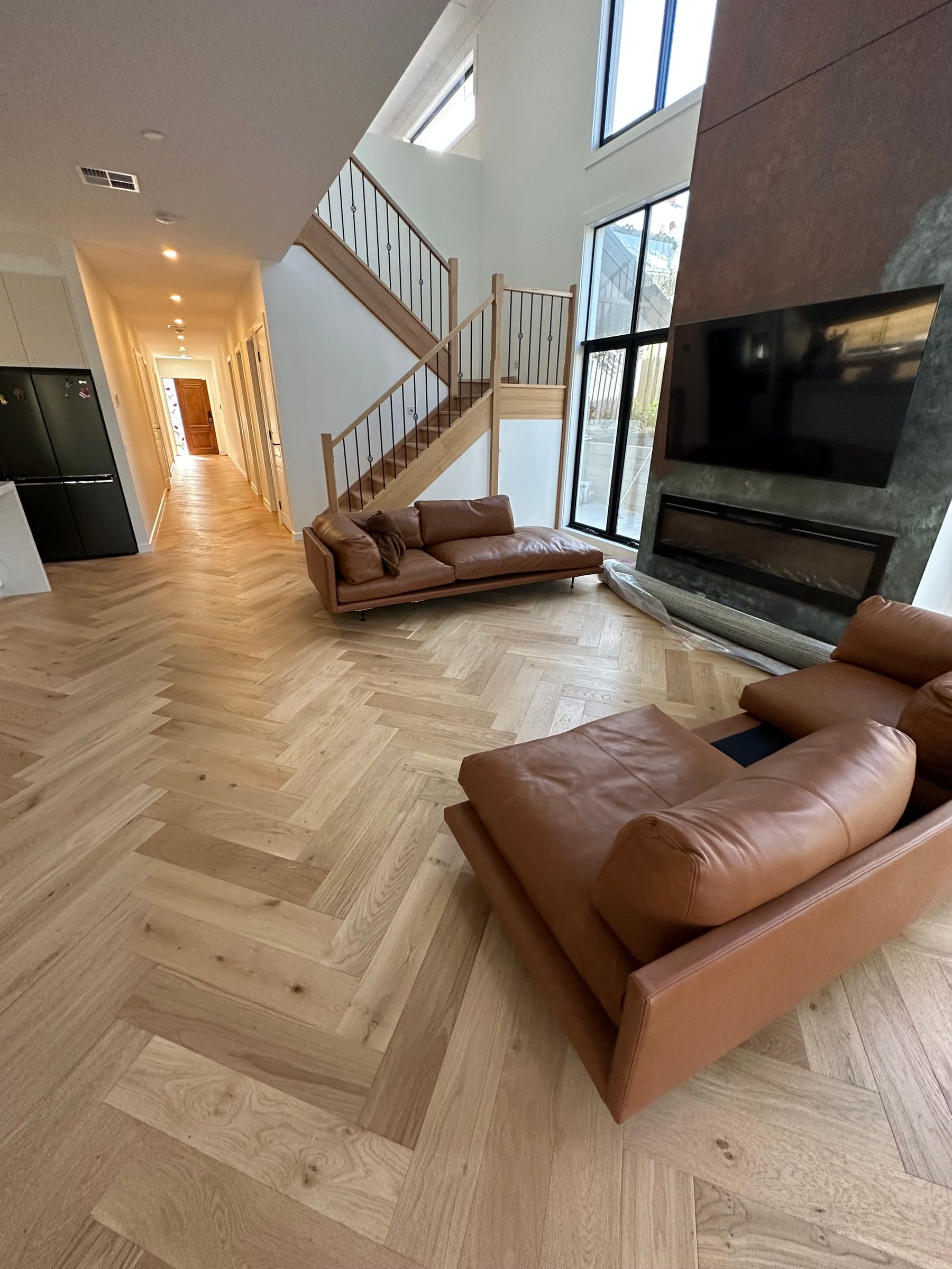 Natural Oak engineered herringbone flooring in a Canterbury living room beside the staircase.