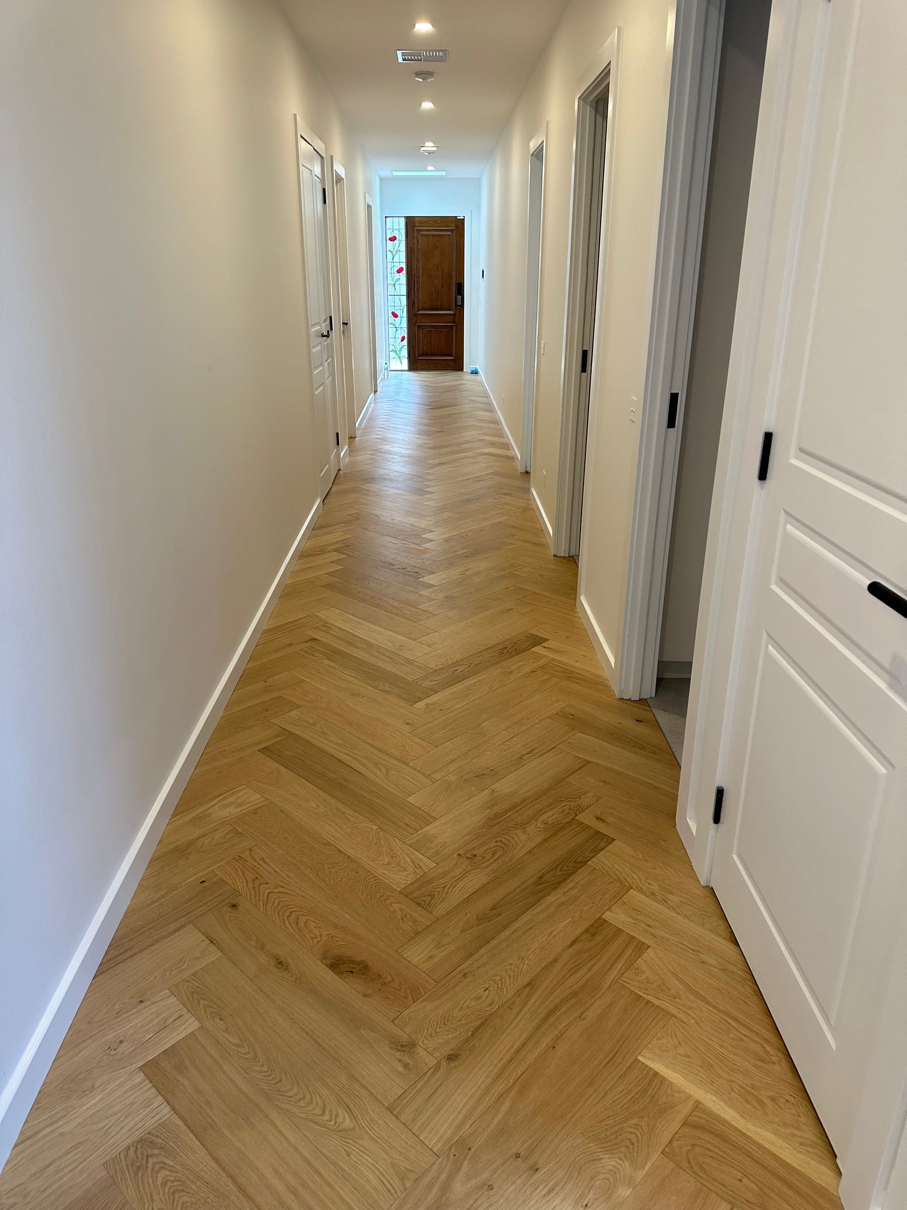 Natural Oak herringbone pattern continuing through a Canterbury hallway.