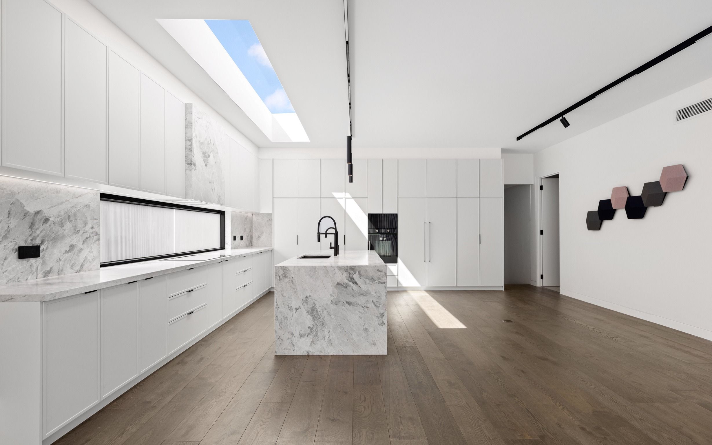 French Grey engineered oak flooring through an open-plan Glen Iris kitchen.
