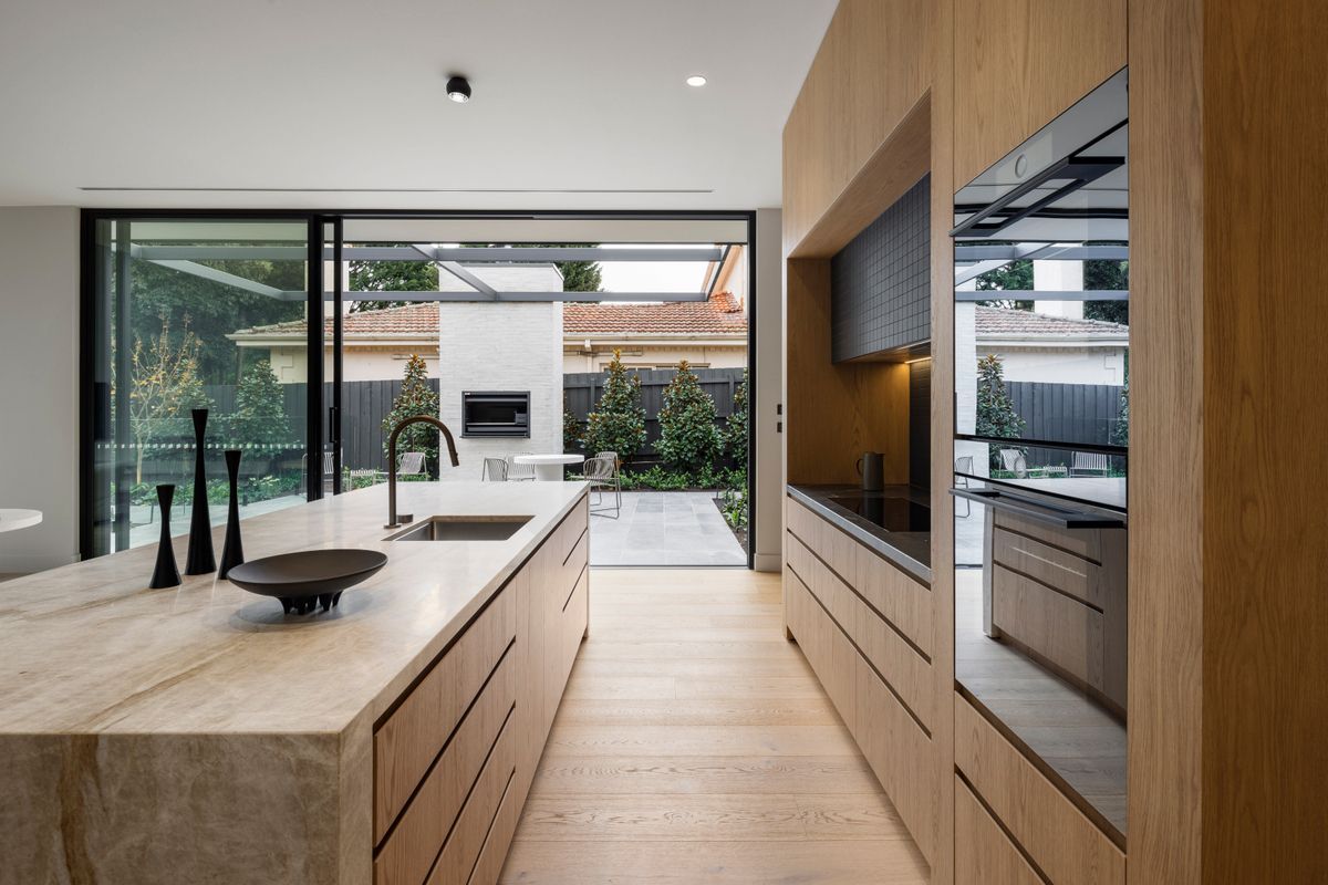 Avoca Bay engineered oak flooring extending through a Kew kitchen to the courtyard.