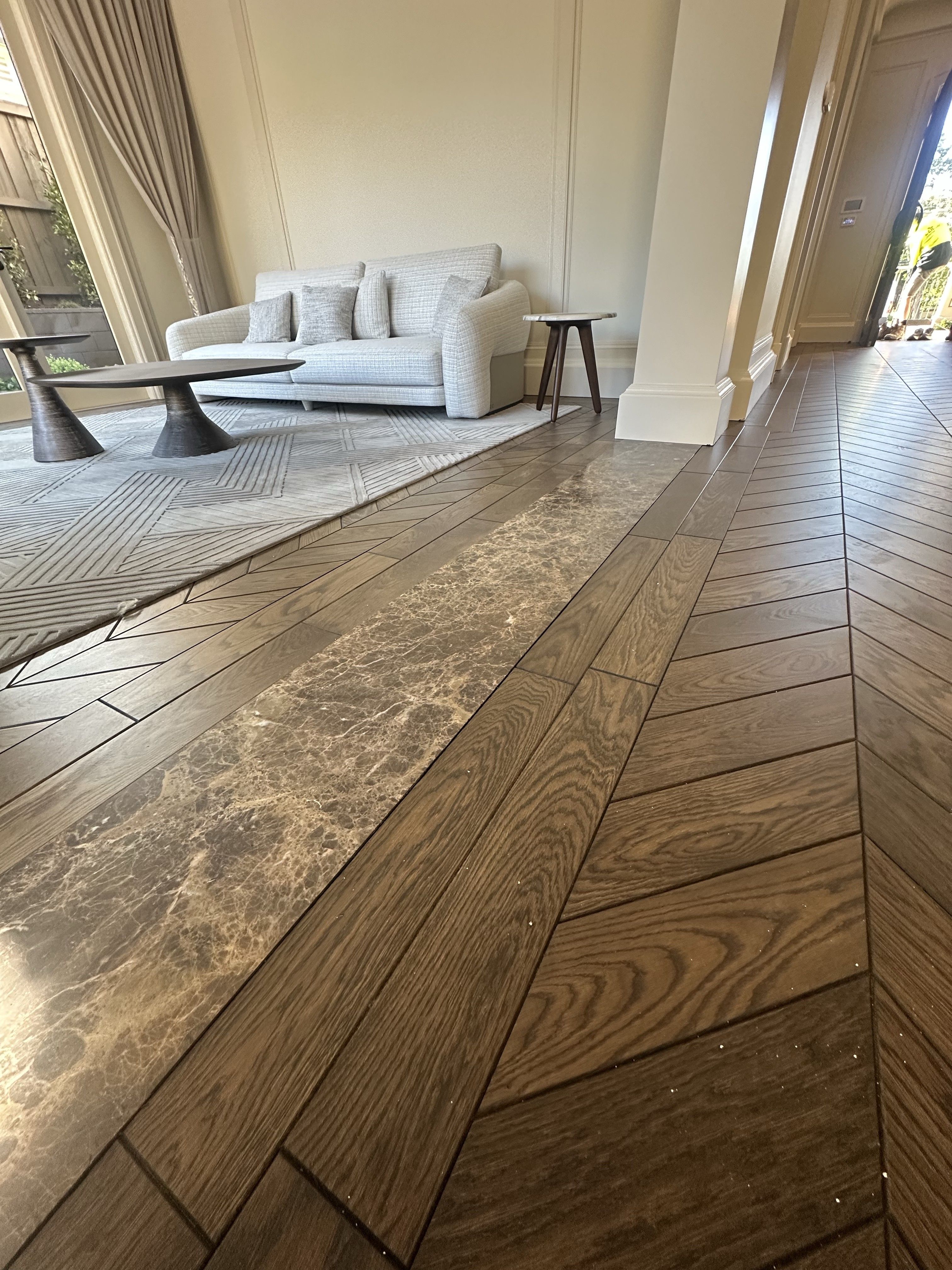 Chevron oak flooring and a decorative stone transition in a Balwyn North living area.
