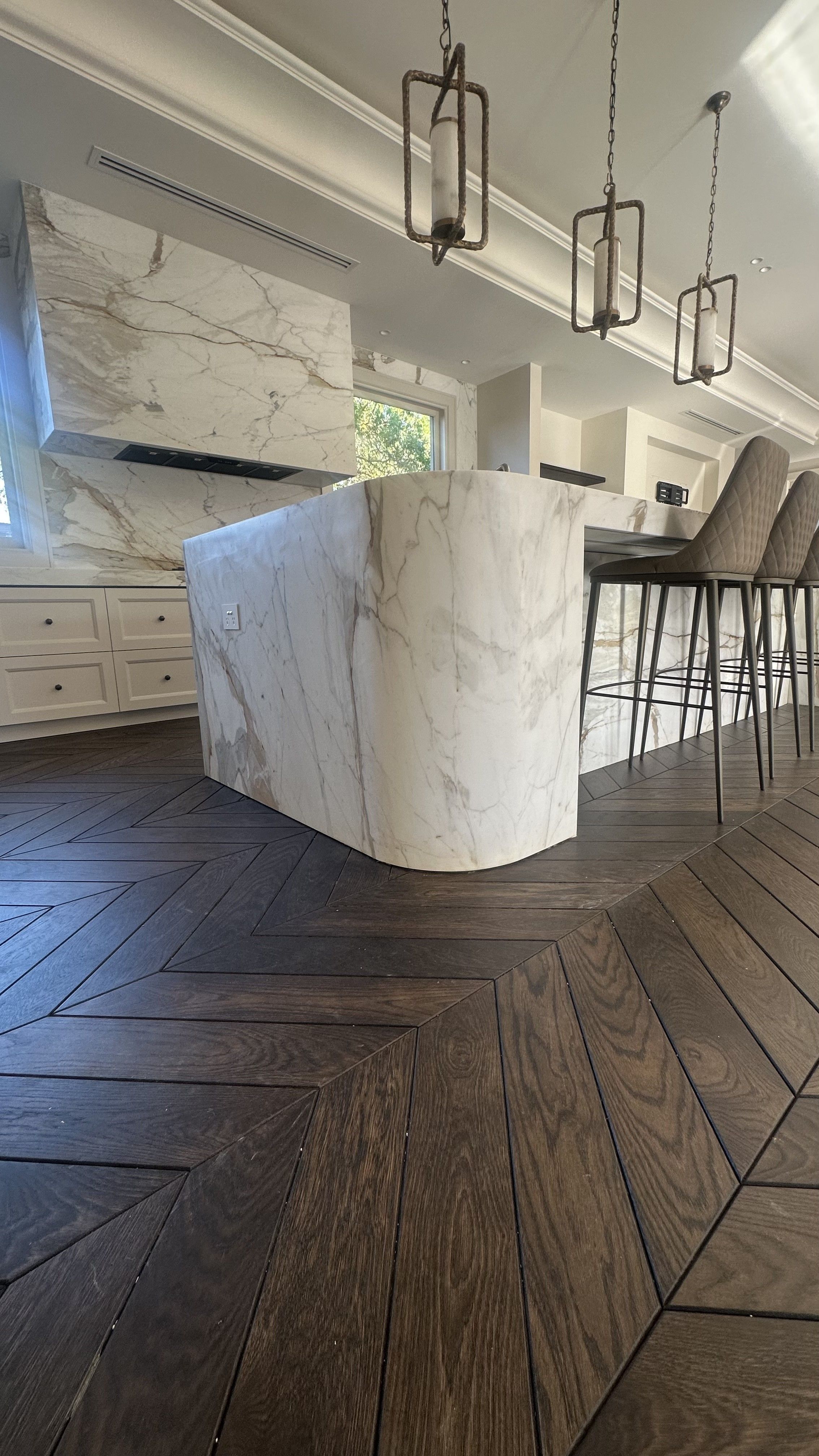 Solid oak chevron flooring surrounding a marble kitchen island in Balwyn North.