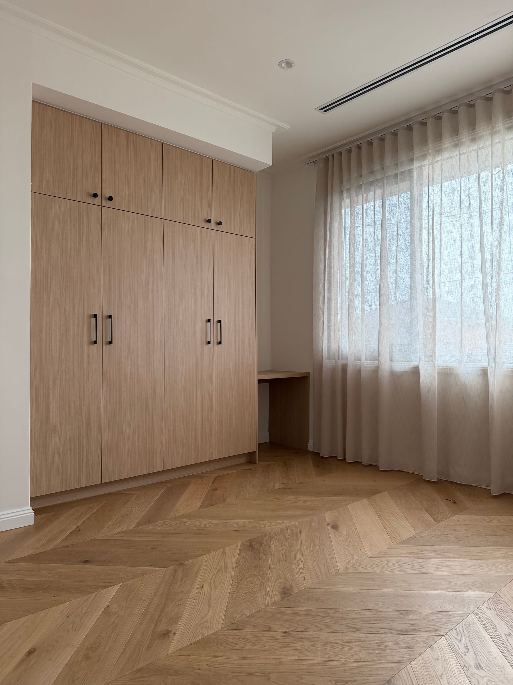 Natural Oak chevron flooring beside built-in timber wardrobes and a study desk in Bulleen.