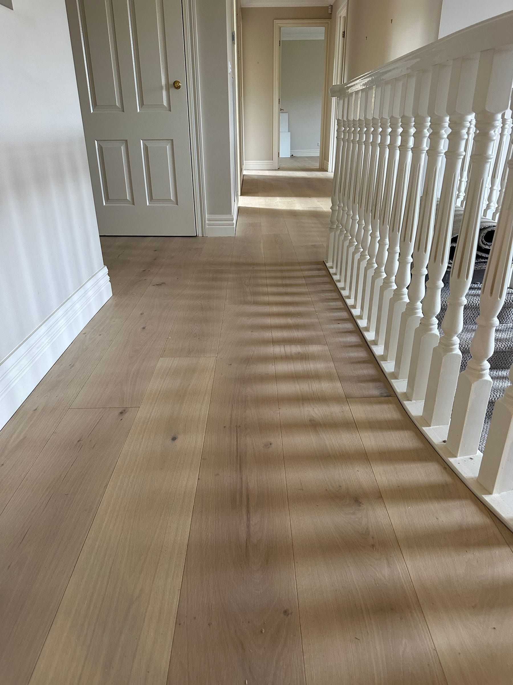 Straight-plank Tealight oak flooring around a curved upstairs balustrade in Camberwell.