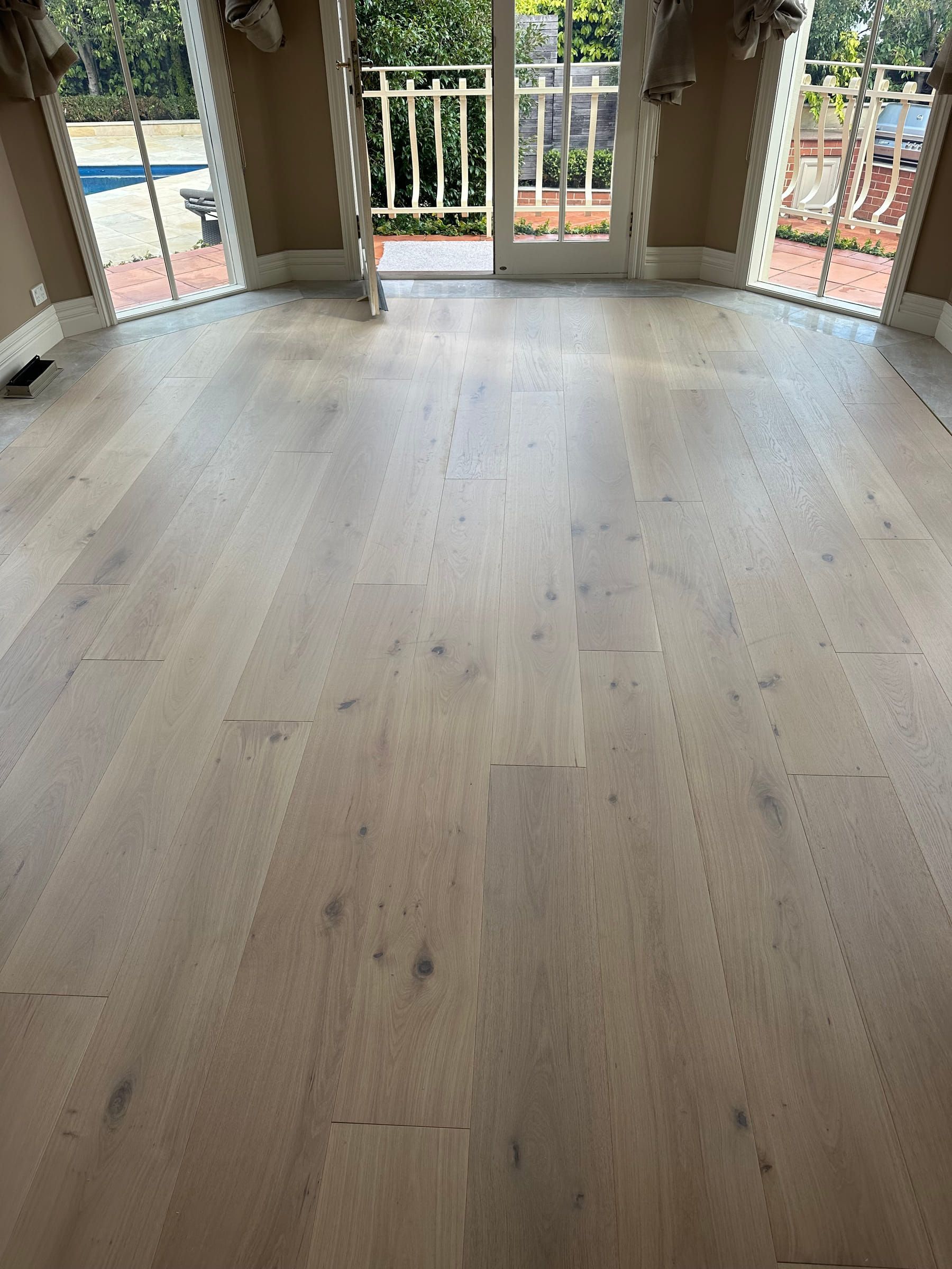 Tealight engineered oak flooring beside glazed doors in a Camberwell room.