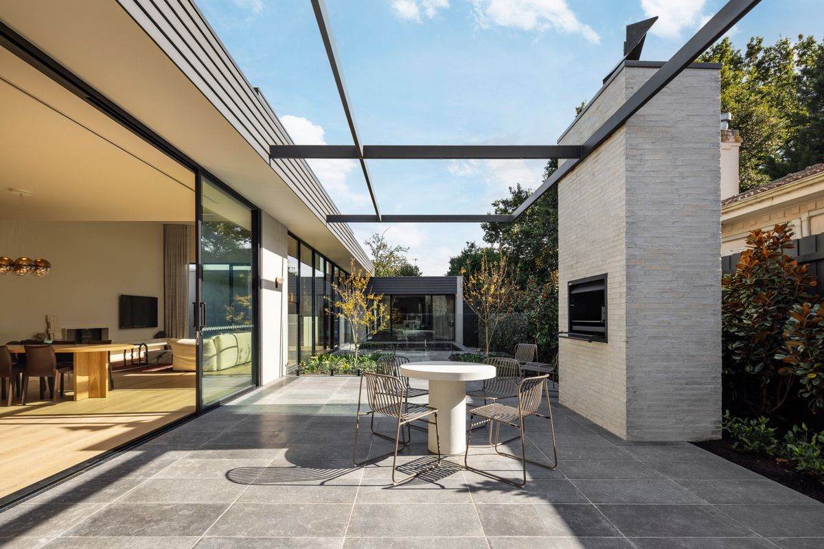 Avoca Bay oak flooring visible through sliding doors beside a Kew courtyard.
