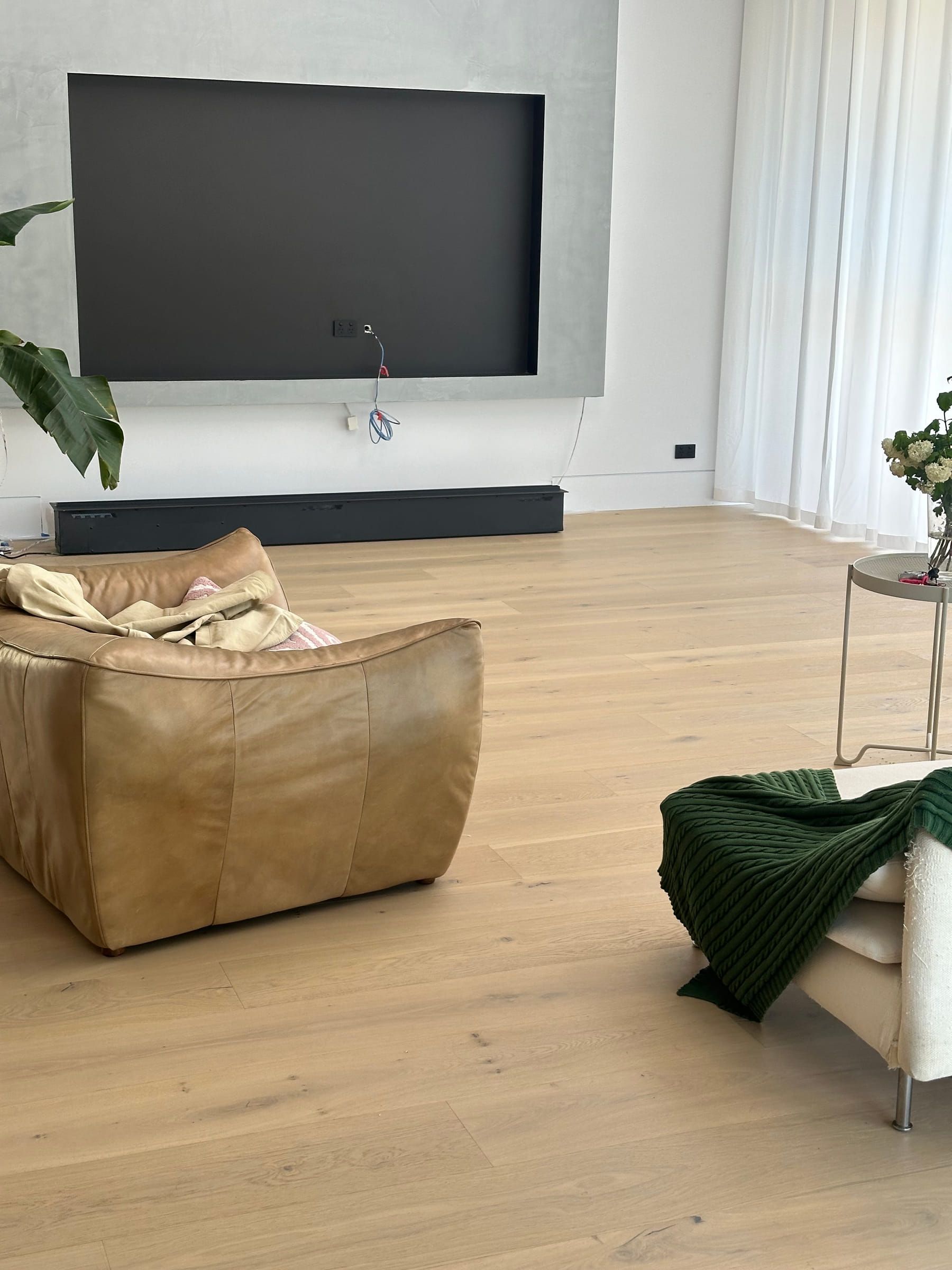 Light Avoca Bay engineered oak flooring beside a leather sofa and media wall in Camberwell.